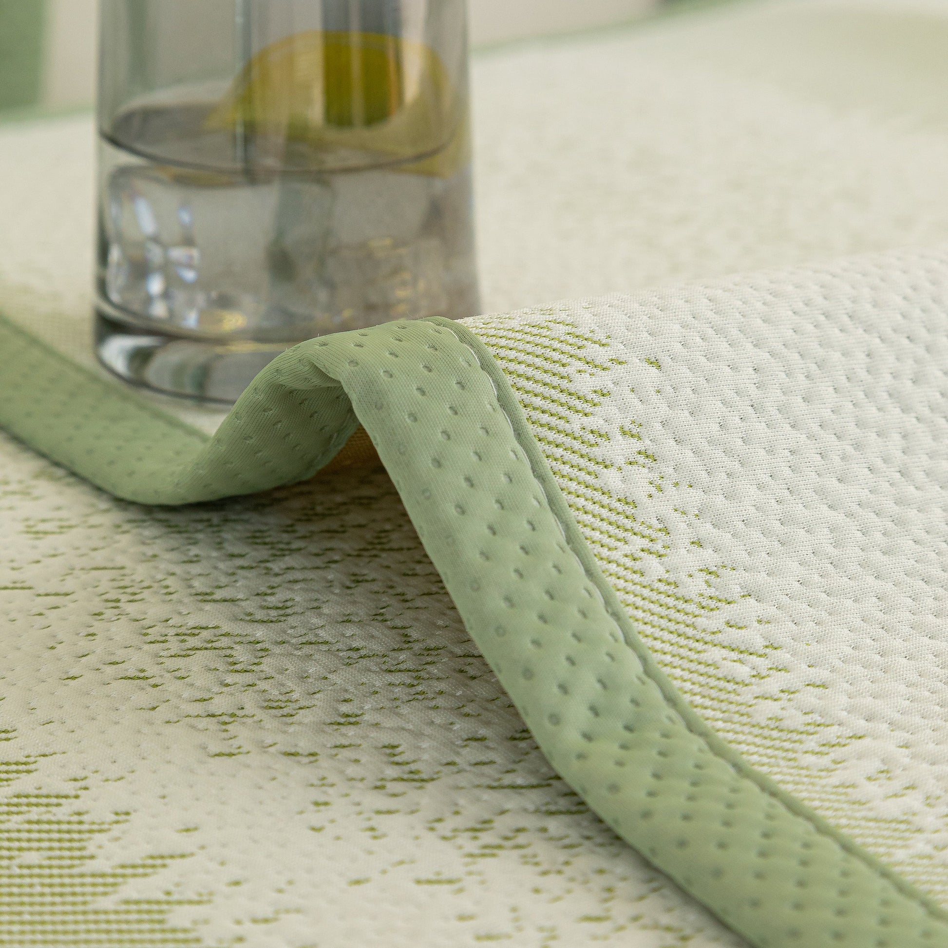 Striped Non-Slip Cooling Couch Cover, Summer Couch Pads for Seat Back Armrest cooling fabric detail with glass of water.
