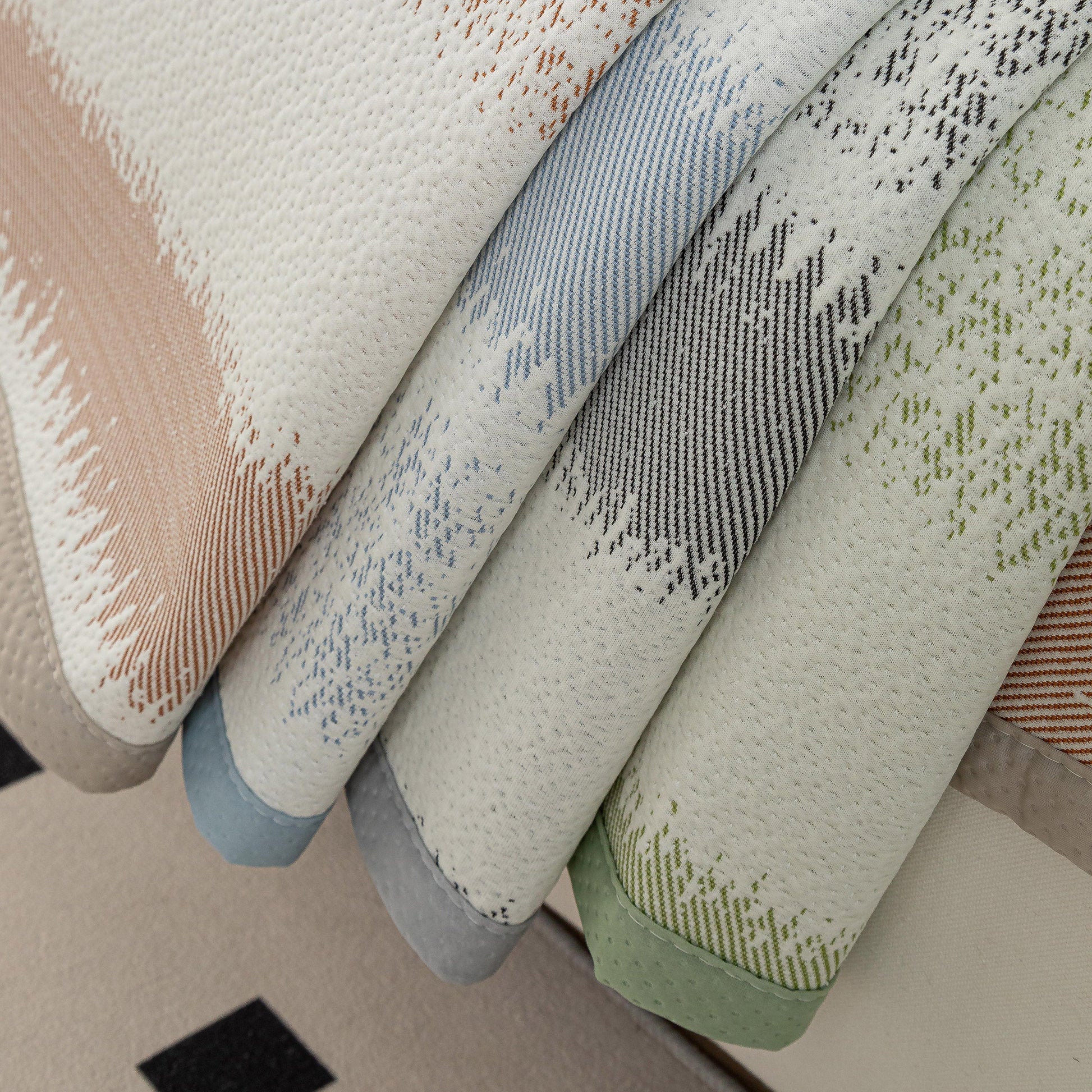 Striped Non-Slip Cooling Couch Cover, Summer Couch Pads for Seat Back Armrest in various colors piled on sofa.