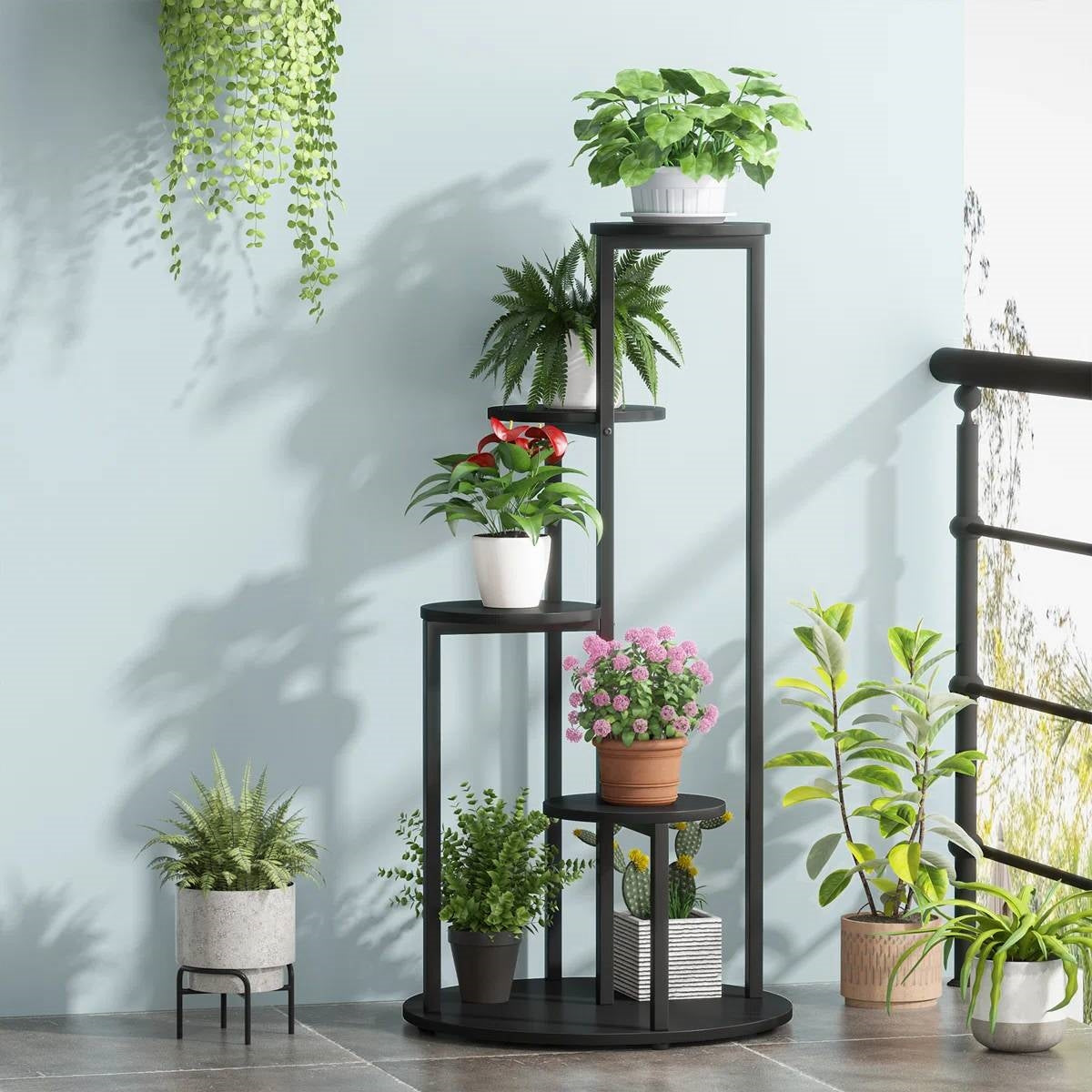 5-Tier Indoor Plant Stand with Black Metal Frame and Brown Wood Finish Shelves displaying various potted plants indoors.