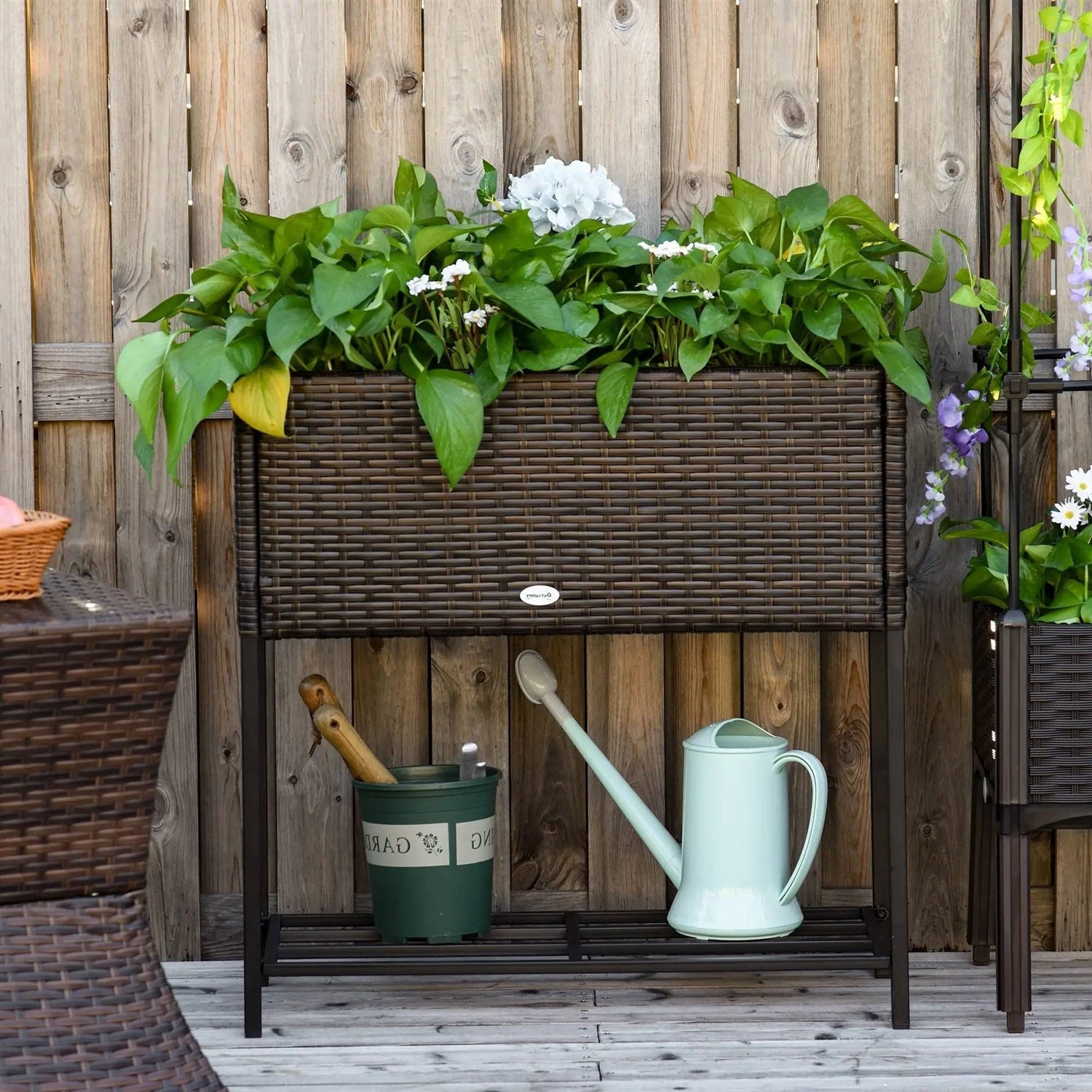 Brown Modern PE Rattan Wicker Raised Garden Bed Elevated Planter Box filled with lush green plants outdoors.