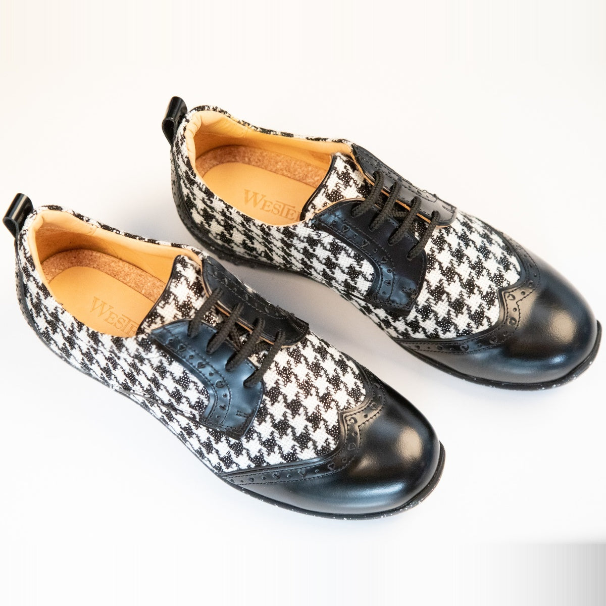 WesTees Javi shoes with houndstooth pattern and black wingtip, featuring foam ankle cushioning and cork insole for unmatched comfort.