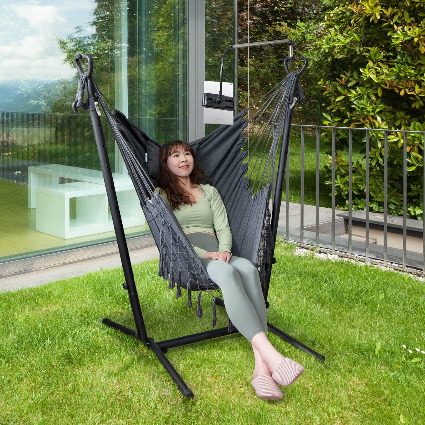 Woman relaxing in Height Adjustable Hammock Chair with Phone Holder and Side Pocket-Gray, enjoying a garden view.