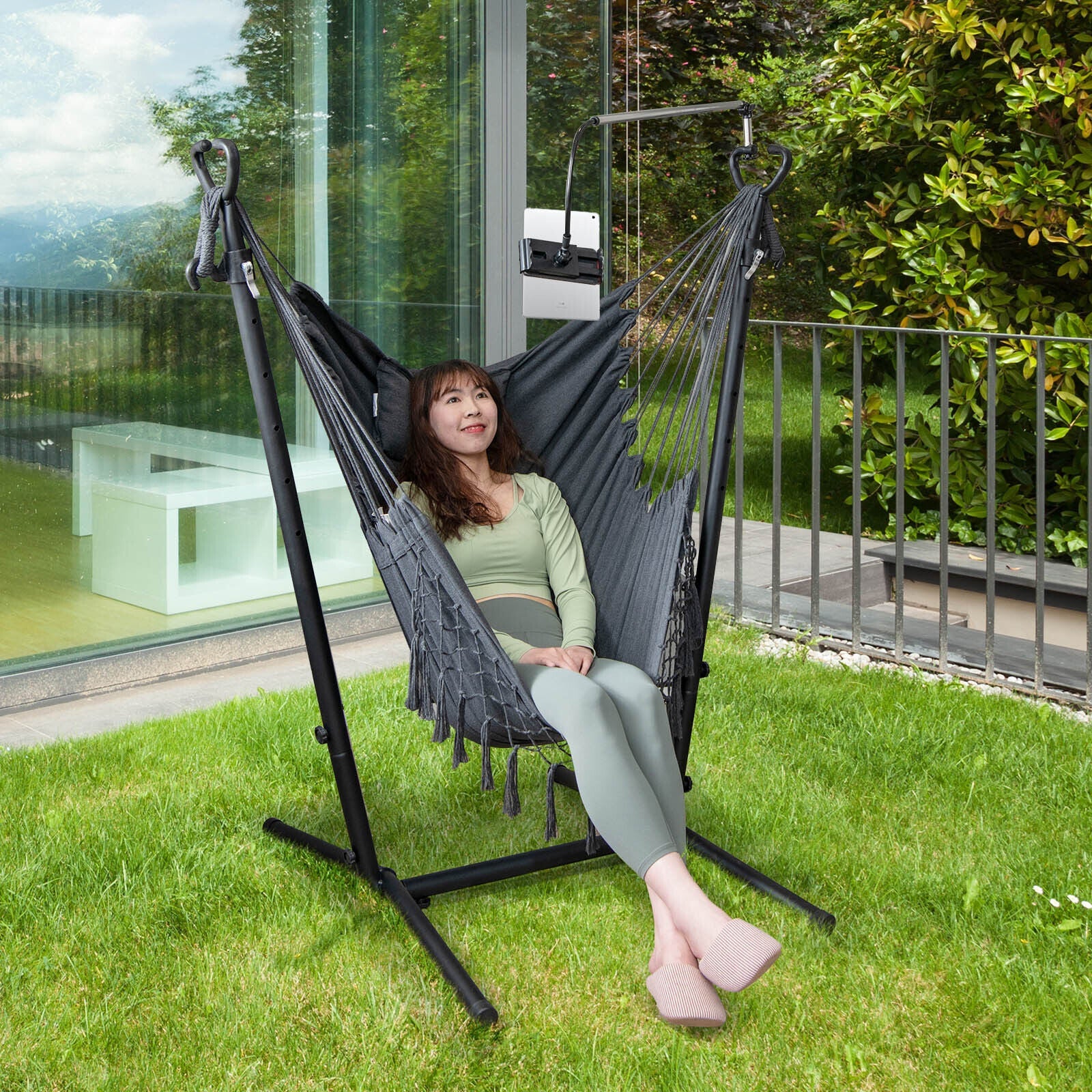 Woman relaxing in Height Adjustable Hammock Chair with Phone Holder and Side Pocket-Gray, enjoying a garden view.