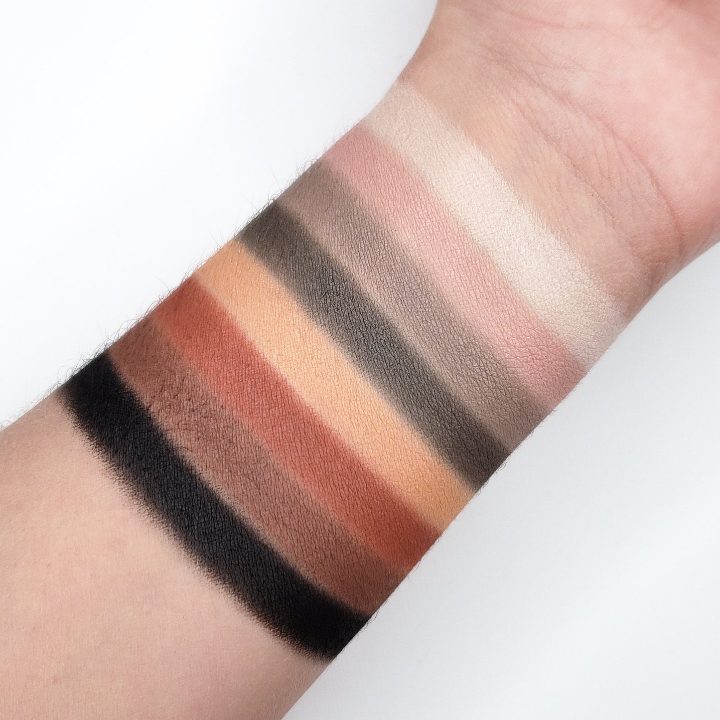 Swatches of BOLD EYESHADOW PALETTE CP08 showcasing various matte and shimmer shades on forearm skin.