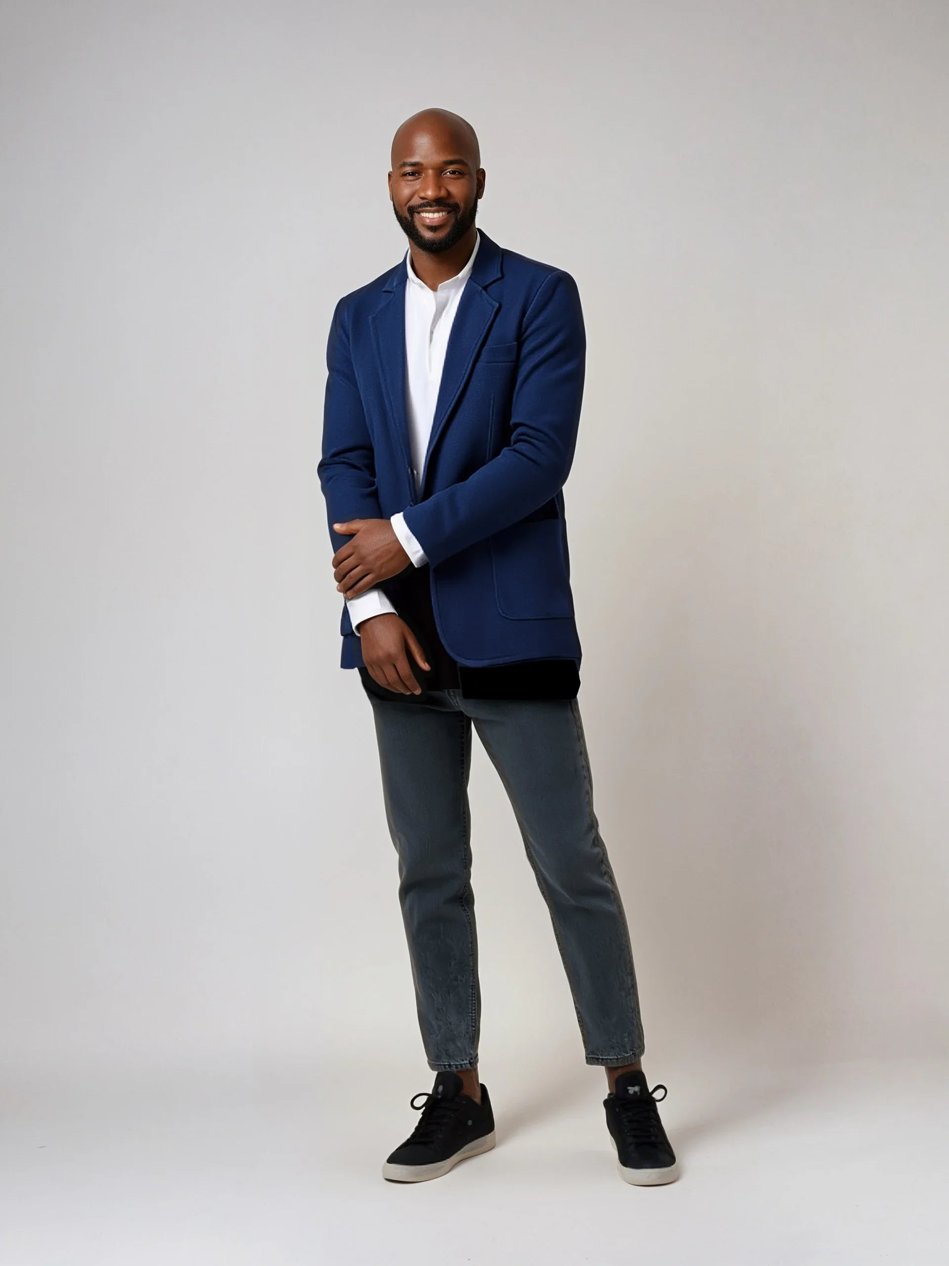 Man wearing a sophisticated Knit Blazer with two buttons and patch pockets, styled with jeans for a classy, versatile look.