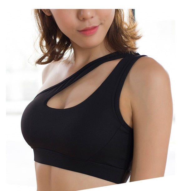 Woman wearing one-shoulder Mermaid Curve Sports Bra in black, ideal for workouts like yoga and running.