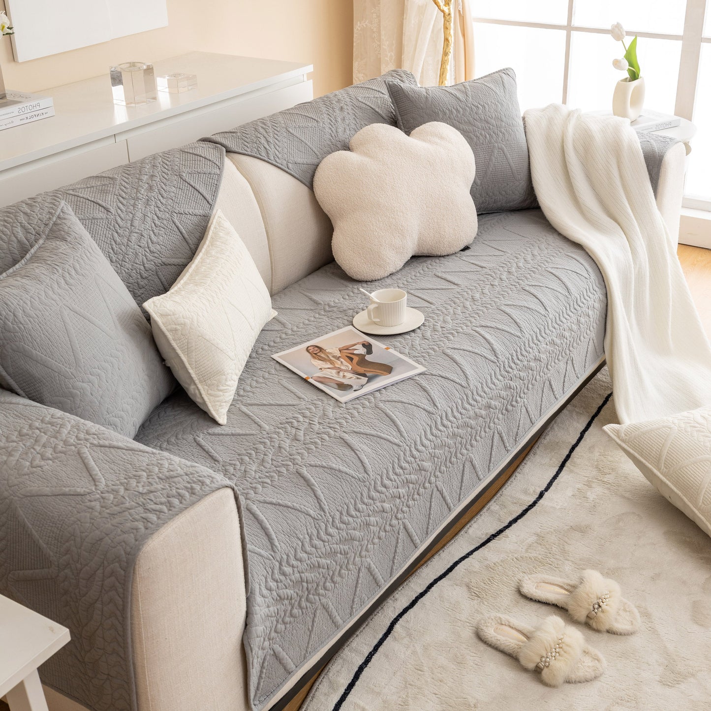 Geometric Textured Cotton Quilted Sofa Cover, Non-Slip Washable Couch Protector on a modern couch with pillows and cup of coffee.