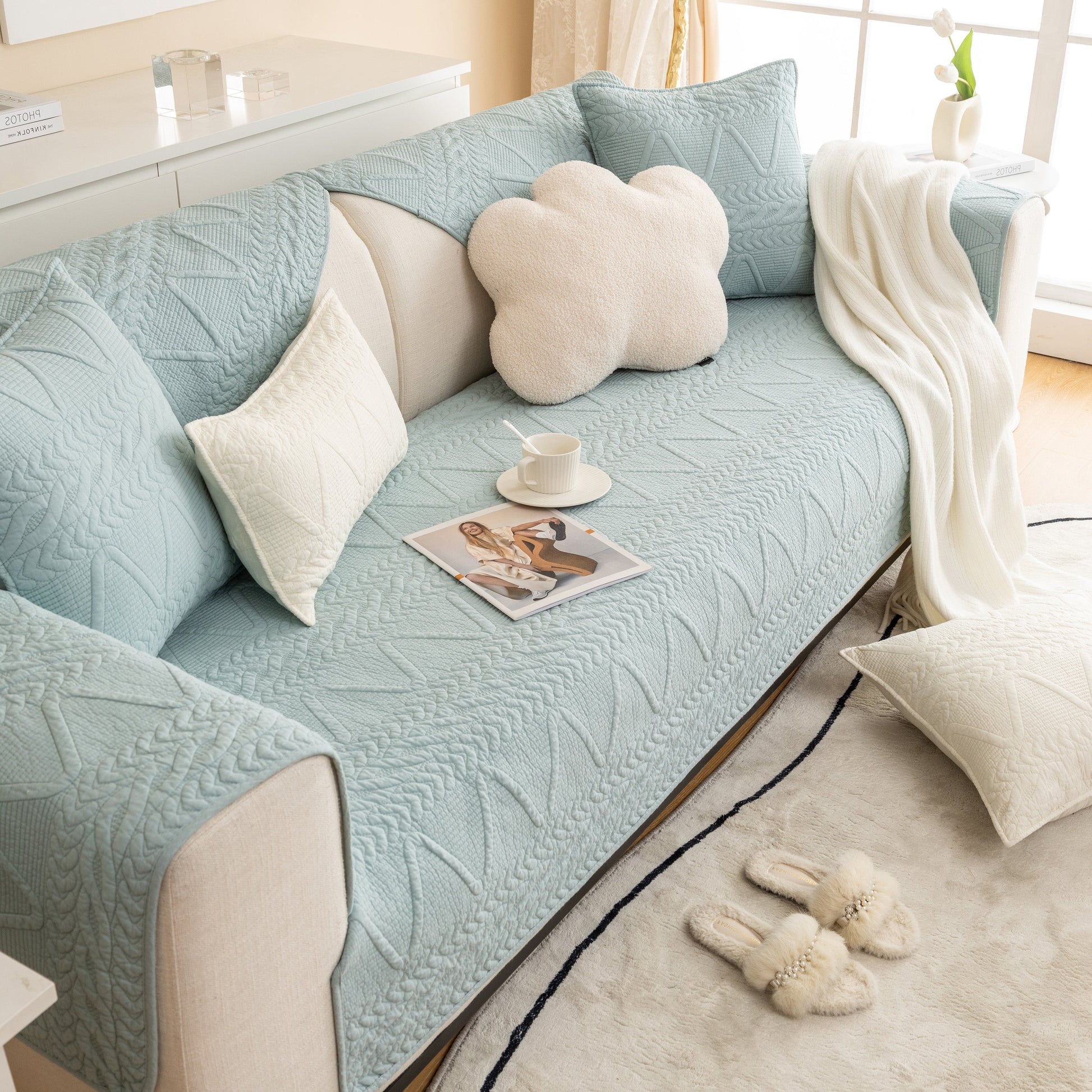 Living room with blue Geometric Textured Cotton Quilted Sofa Cover, Non-Slip Washable Couch Protector and cloud pillow.