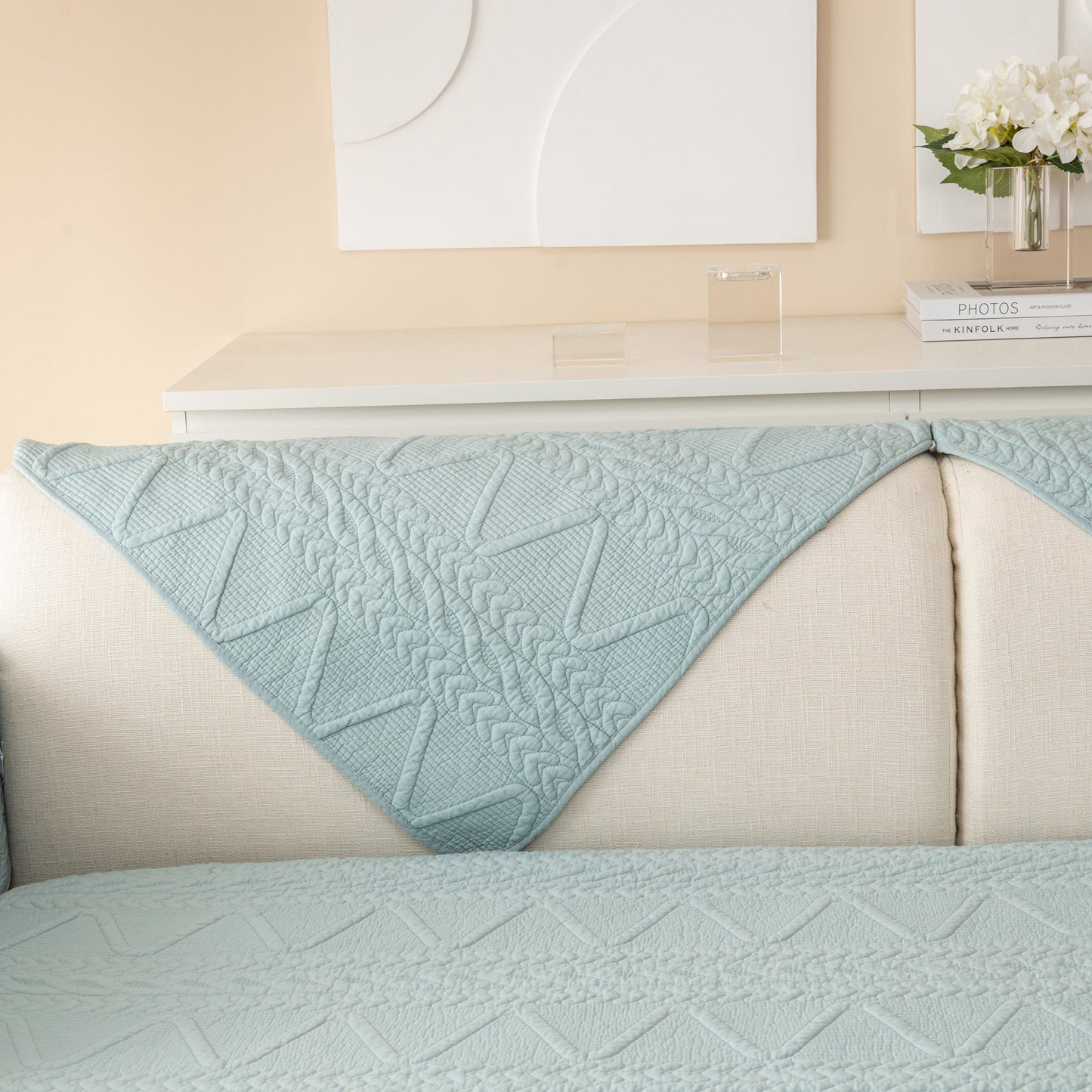Geometric Textured Cotton Quilted Sofa Cover, Non-Slip Washable Couch Protector with sculptural V-shaped motifs on a couch.