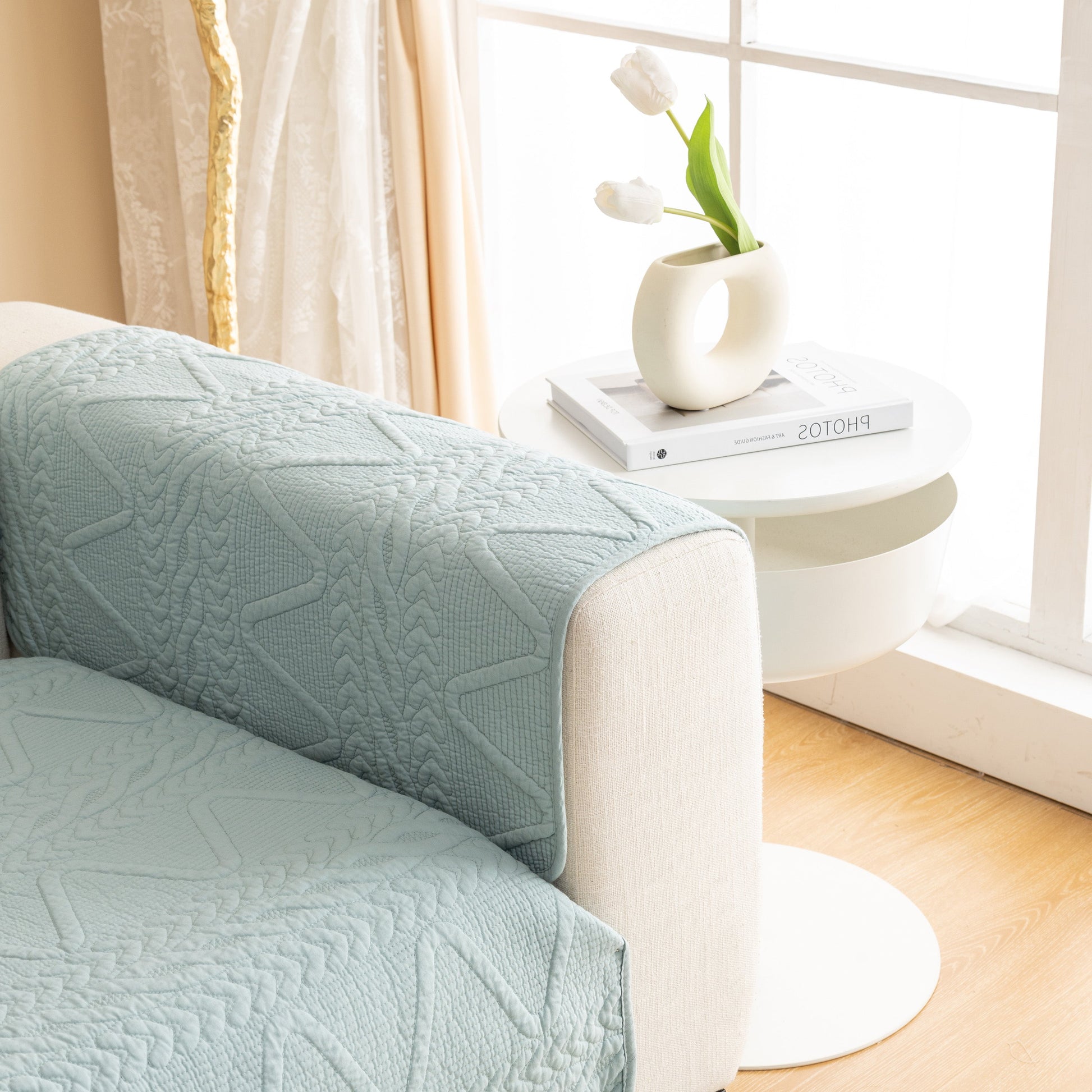 Geometric Textured Cotton Quilted Sofa Cover, Non-Slip Washable Couch Protector draped elegantly on a sofa in a modern living room.