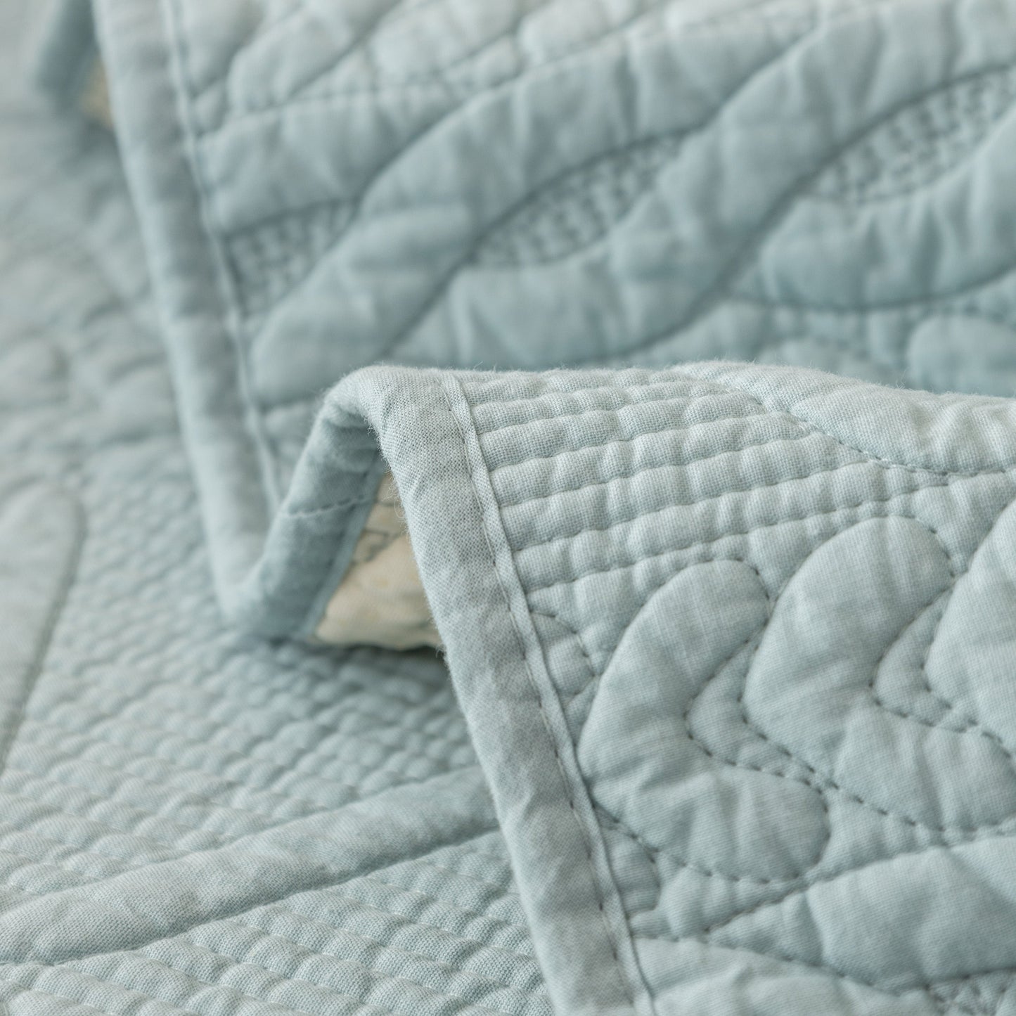 Geometric Textured Cotton Quilted Sofa Cover, Non-Slip Washable Couch Protector with architectural stitching in blue fabric.