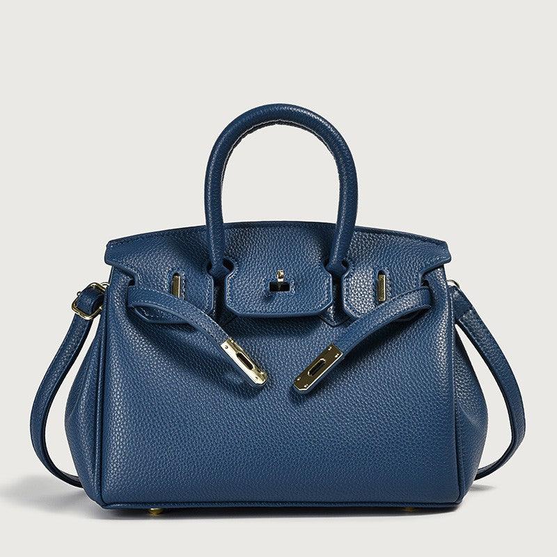 Blue leather handbag with top handles and gold hardware.