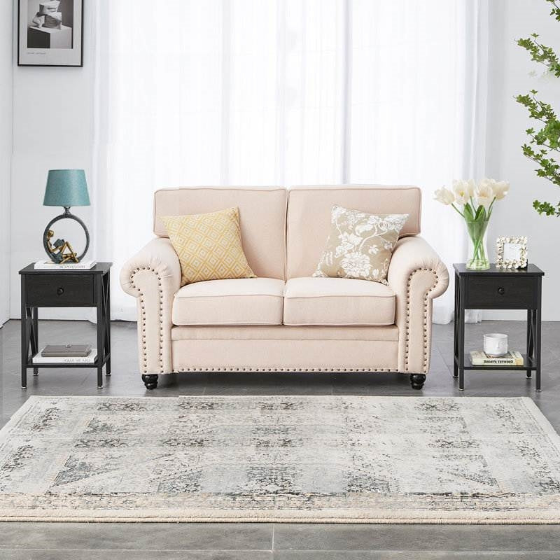 Living room with Set of 2 - Rustic 1 Drawer Black Nightstand with X-Shaped Sides, beige sofa, and decorative accents.