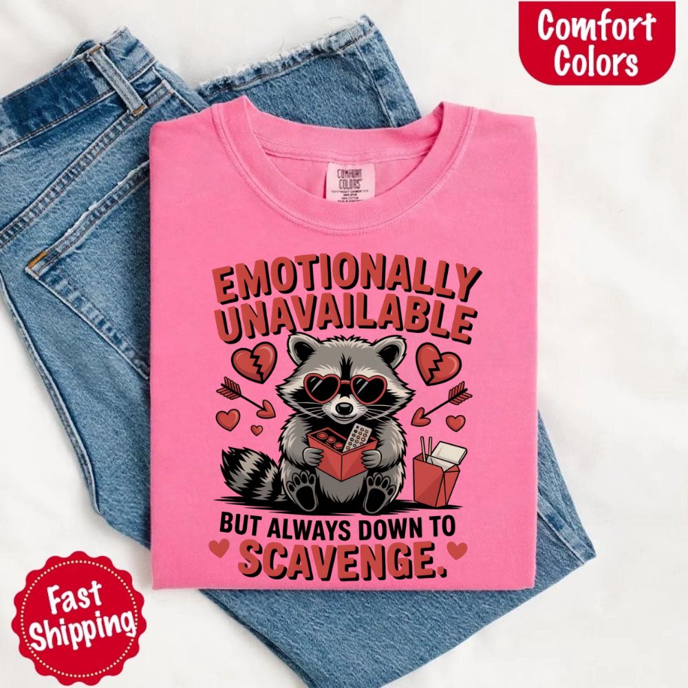 Comfort Colors Emotionally Unavailable Raccoon T-Shirts featuring pink tee with moody raccoon and heart graphics, ultra-soft cotton.