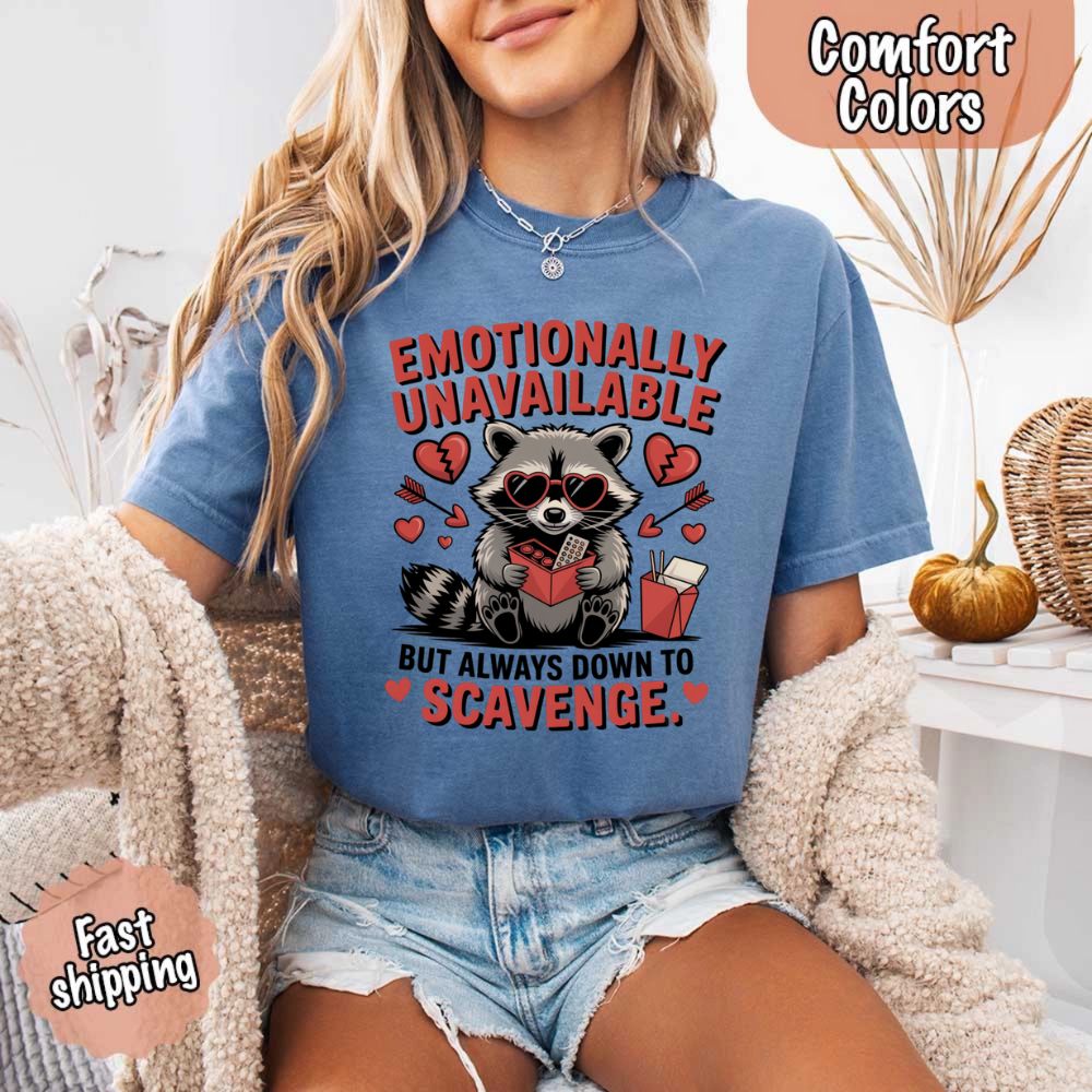 Woman wearing Comfort Colors Emotionally Unavailable Raccoon T-Shirts with moody raccoon design, fast shipping.