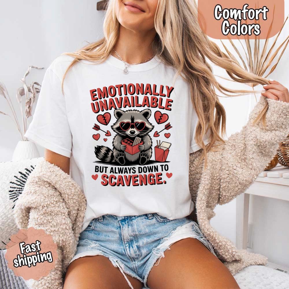 Woman wearing Comfort Colors Emotionally Unavailable Raccoon T-Shirts, featuring a moody raccoon print, promoting emotional humor fashion.