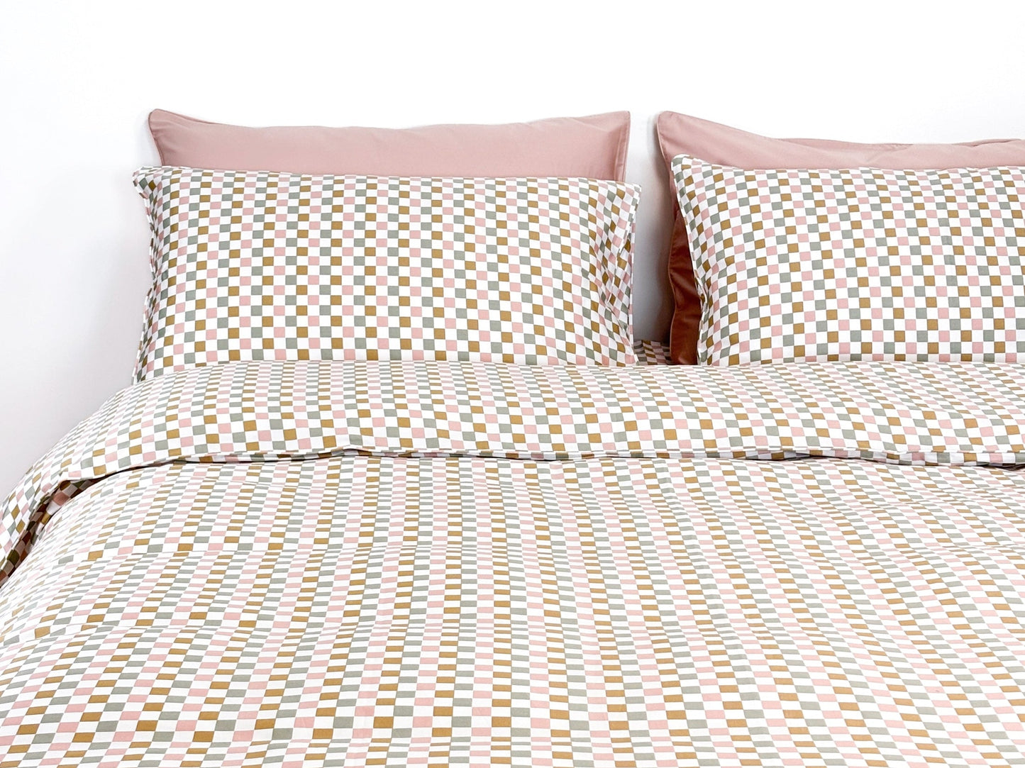 SHNUGGLE Bedding Set Colorful Checker displayed on bed with pillowcases and duvet cover in pastel hues.