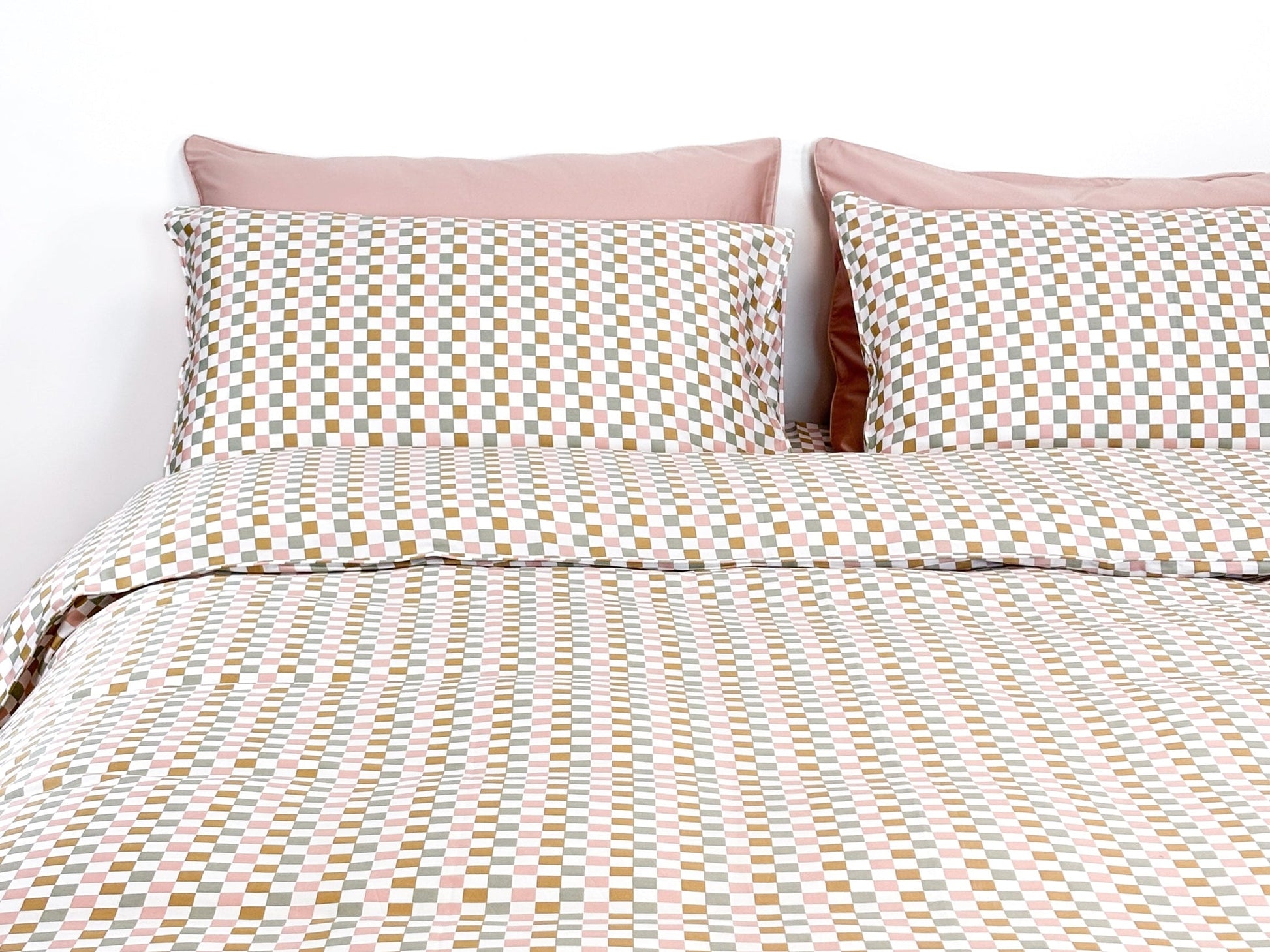 SHNUGGLE Bedding Set Colorful Checker displayed on bed with pillowcases and duvet cover in pastel hues.