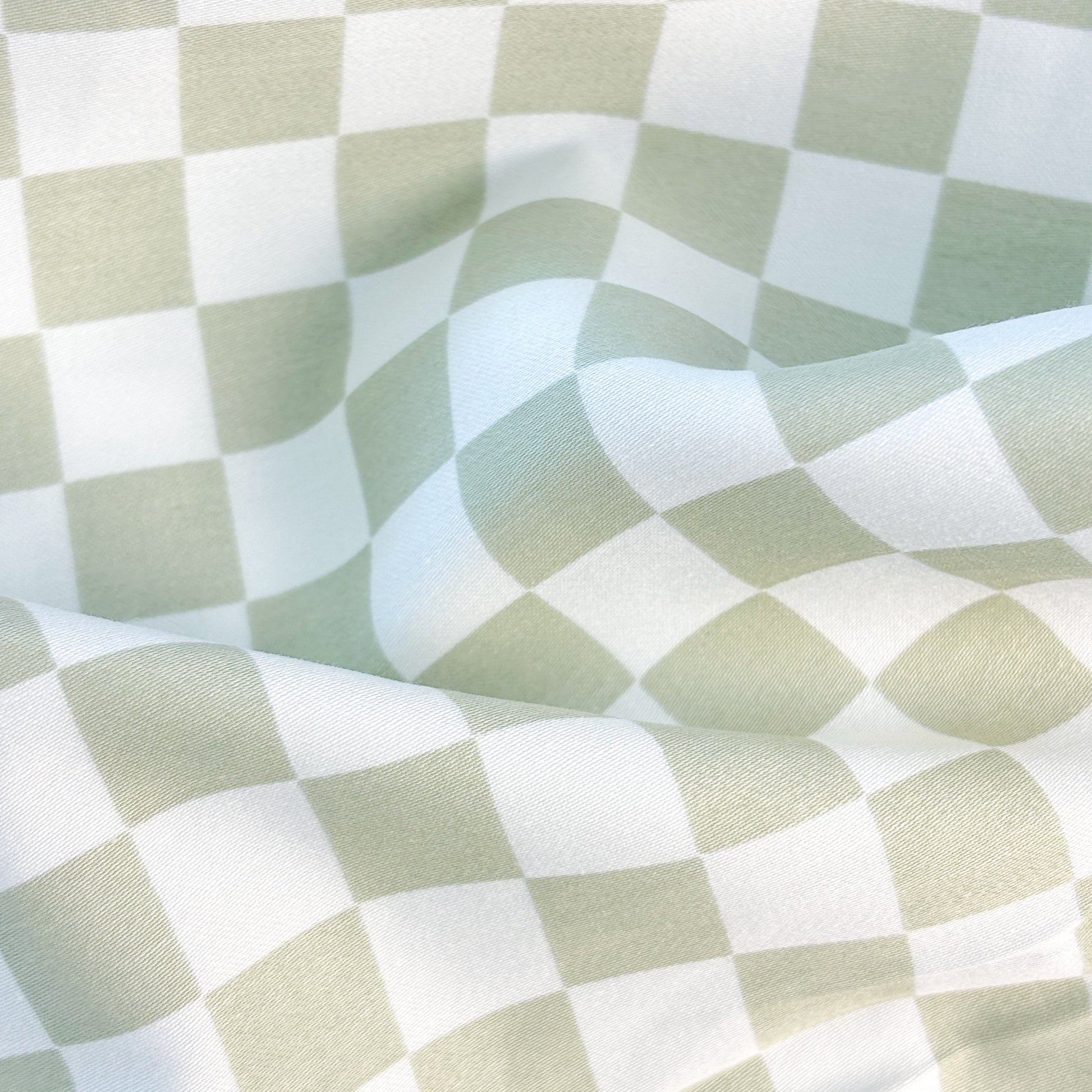 Close-up of SHNUGGLE Bedding Set Sage Checker fabric showcasing green and white checkered pattern.