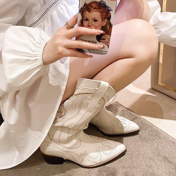 Woman wearing Autumn Moon Cowgirl Boots with stylish stitched pattern, showcasing light beige color and mid-calf height