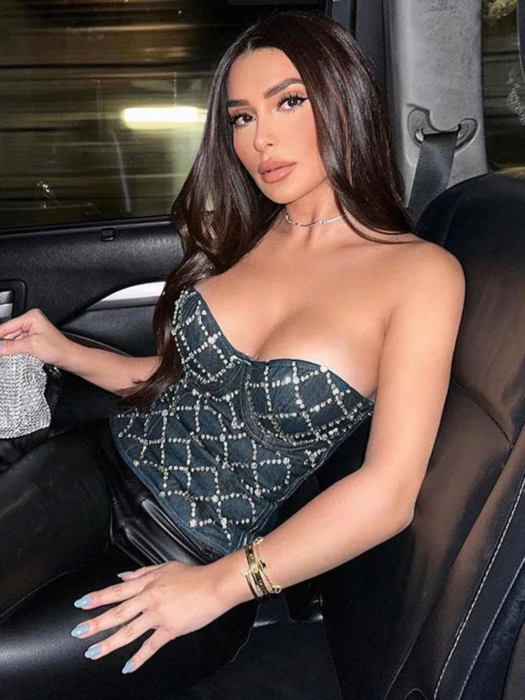 Woman wearing a sparkling rhinestone-decorated top, sitting in a car seat.