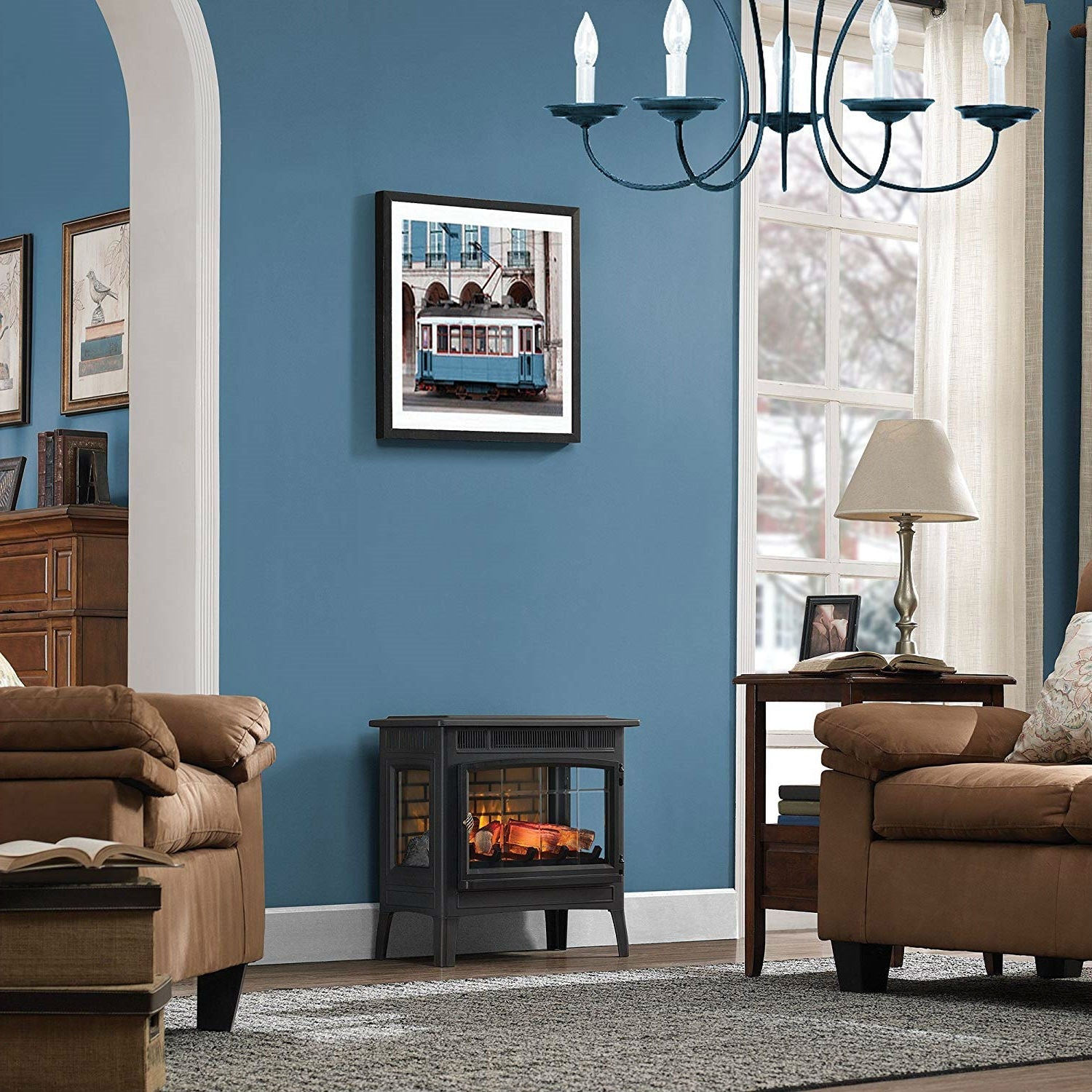 Elegant living room with Black Infrared Quartz Electric Fireplace Stove Heater under artwork on a blue wall.
