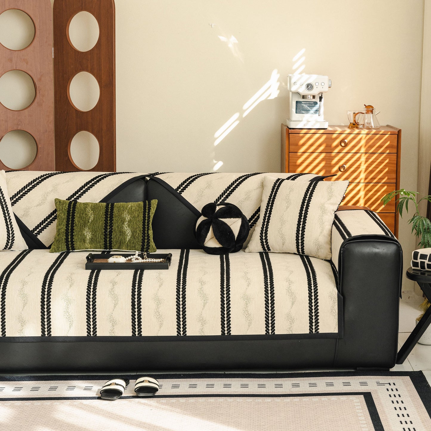 Non-Slip Sofa Cover with Thick Chenille Texture Woven Stripe Couch Protector Throw on a black leather sofa in a modern living room