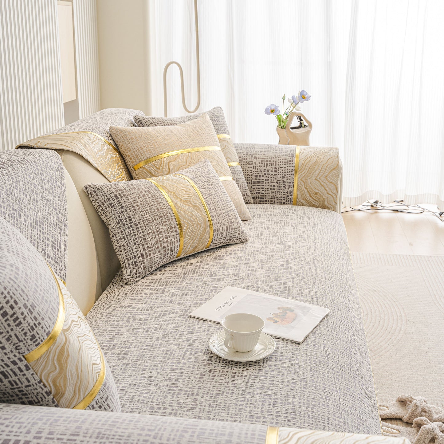 Modern Non-Slip Couch Slipcover, Soft, Durable & Washable Furniture Protector with gold marble trim on a gray sofa.