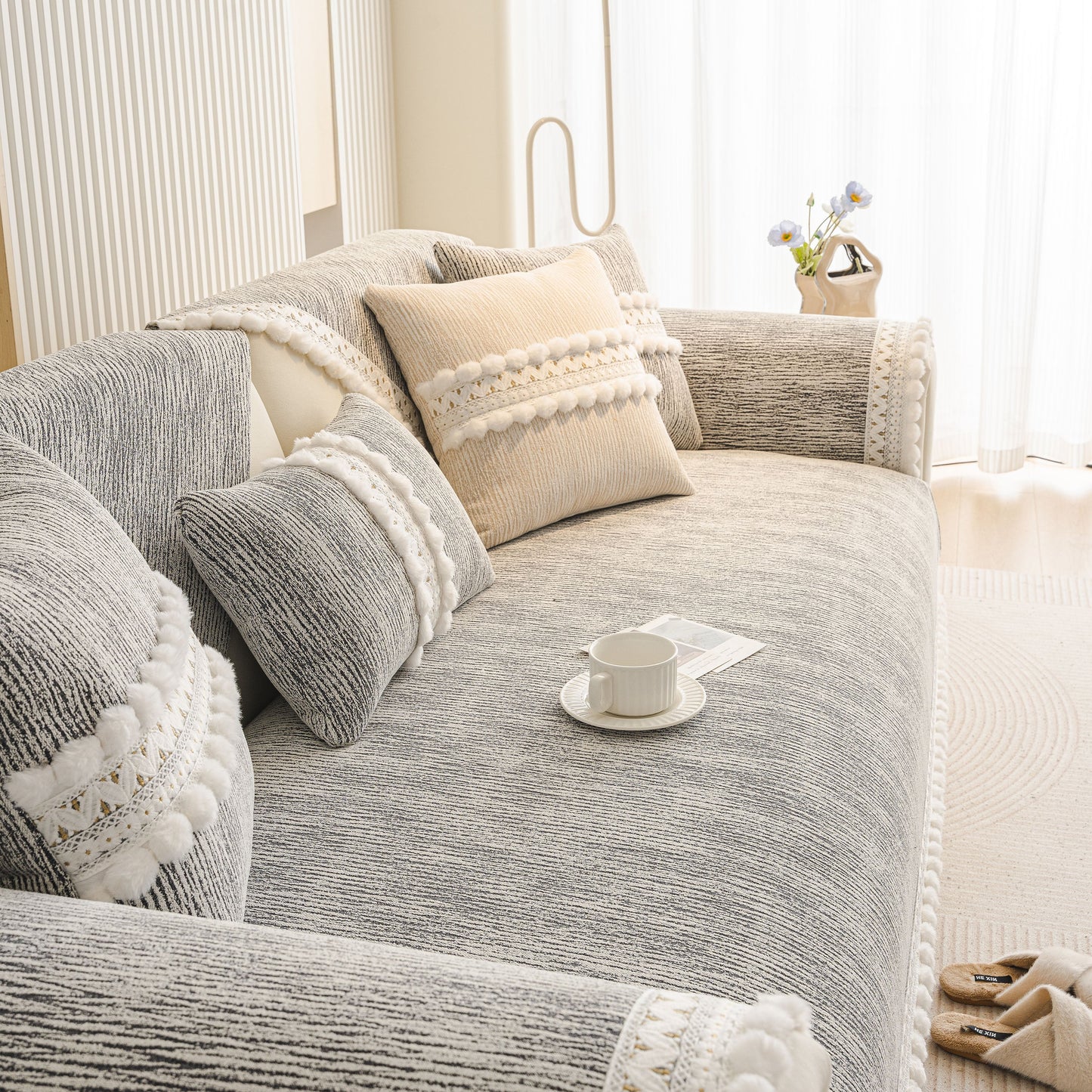 Soft Chenille Sectional Sofa Cover with Pom Pom Trim – Non-Slip Couch Protector in gray with decorative pillows and trim.