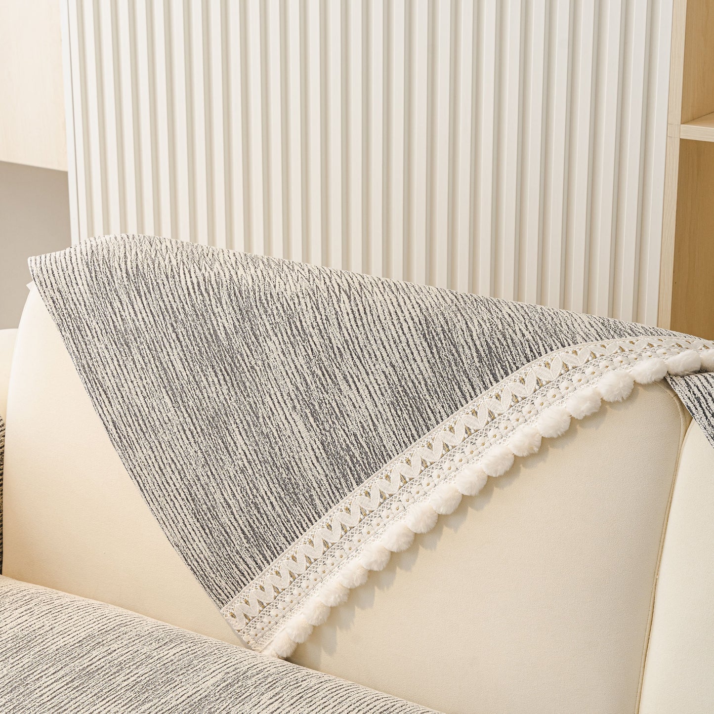 Soft Chenille Sectional Sofa Cover with Pom Pom Trim – Non-Slip Couch Protector on a light-colored sofa, featuring lace trim and pom poms.