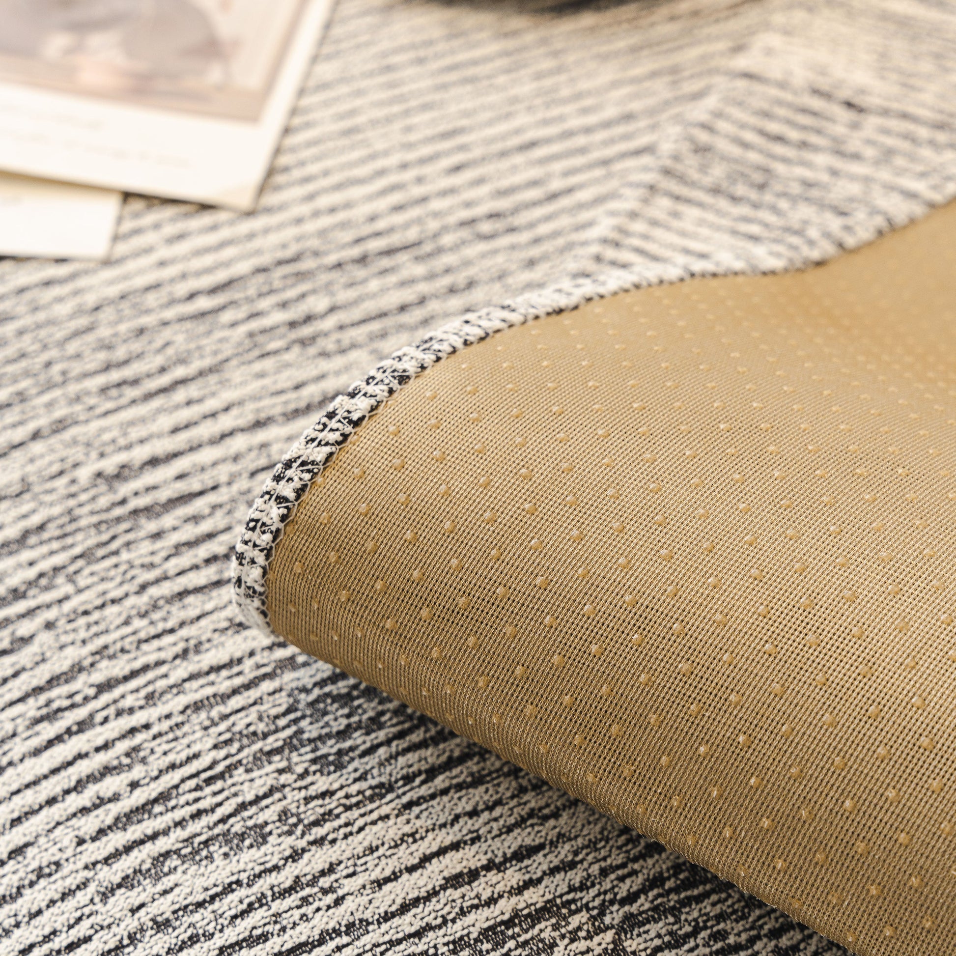 Close-up of Soft Chenille Sectional Sofa Cover with Pom Pom Trim showing non-slip backing and textured stripes.