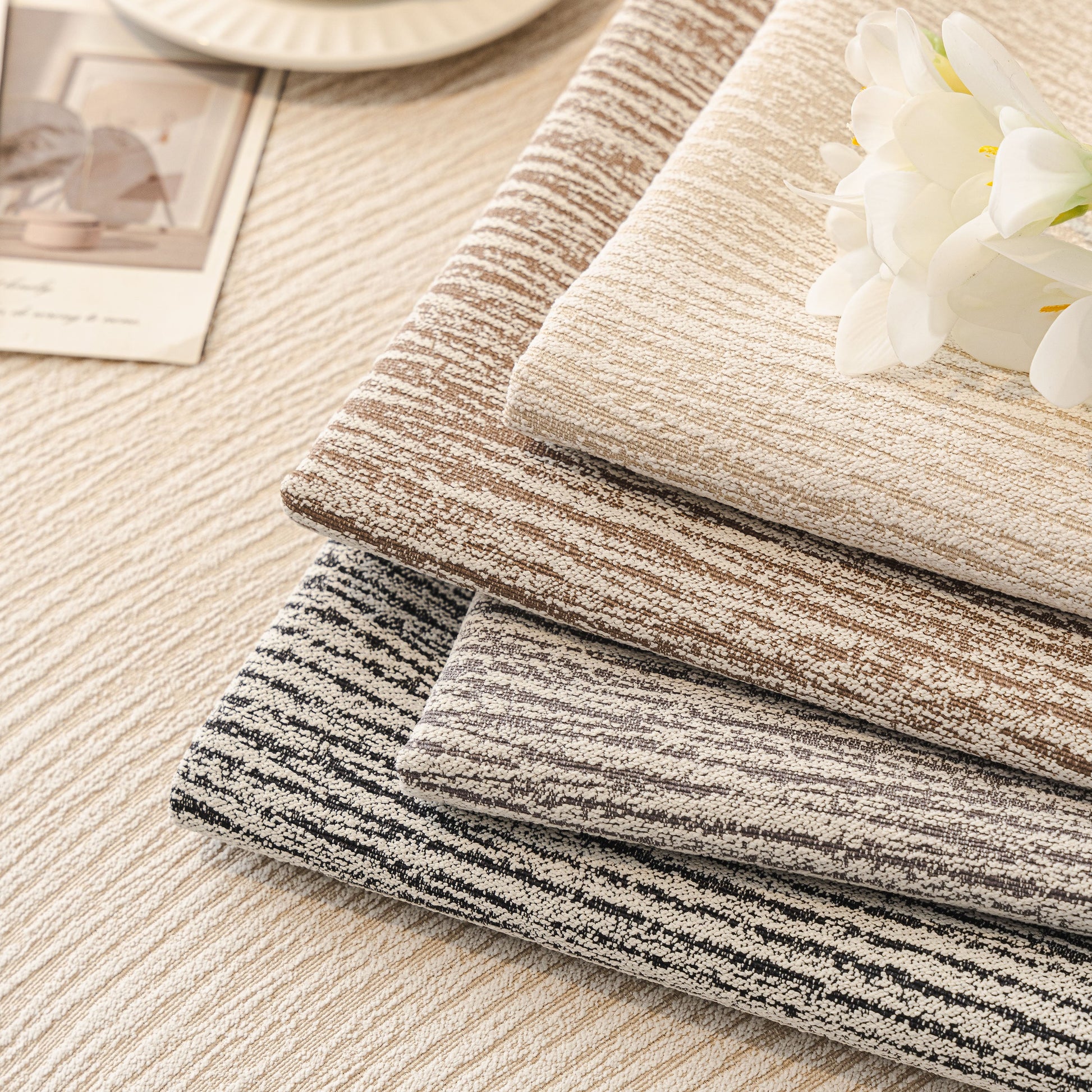 Soft Chenille Sectional Sofa Cover with Pom Pom Trim – Non-Slip Couch Protector in elegant textured fabric, stacked neatly with flower accent.