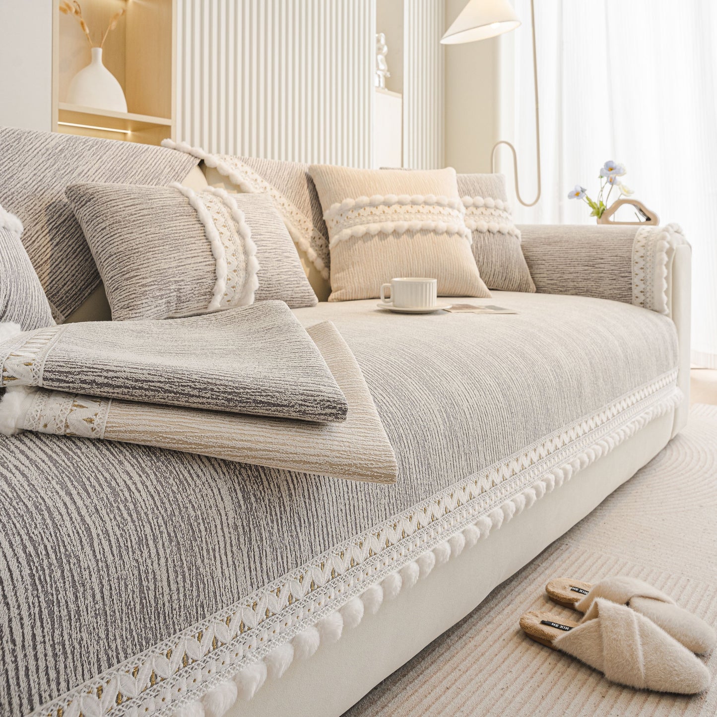 Soft Chenille Sectional Sofa Cover with Pom Pom Trim – Non-Slip Couch Protector on a beige sofa highlighting decorative fringe.