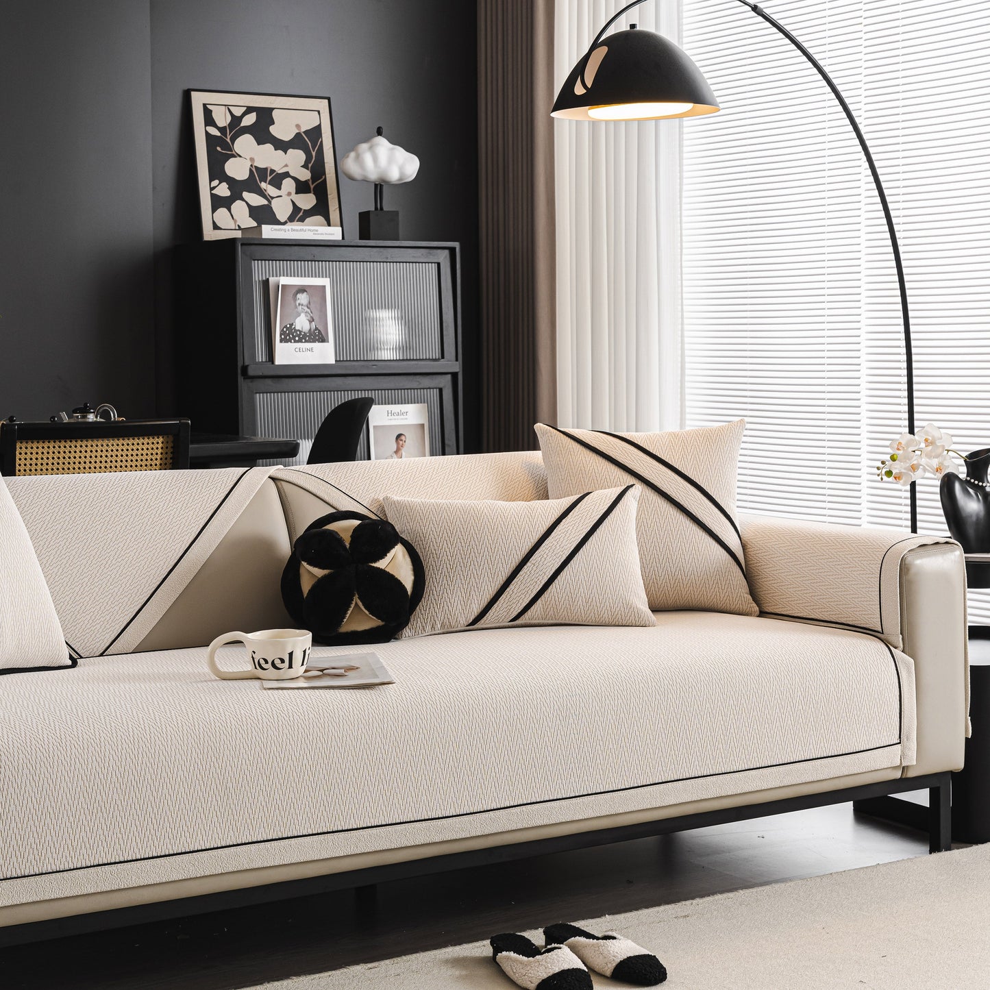 Modern living room with a beige couch featuring black striped pillows and under a stylish black arc lamp.
