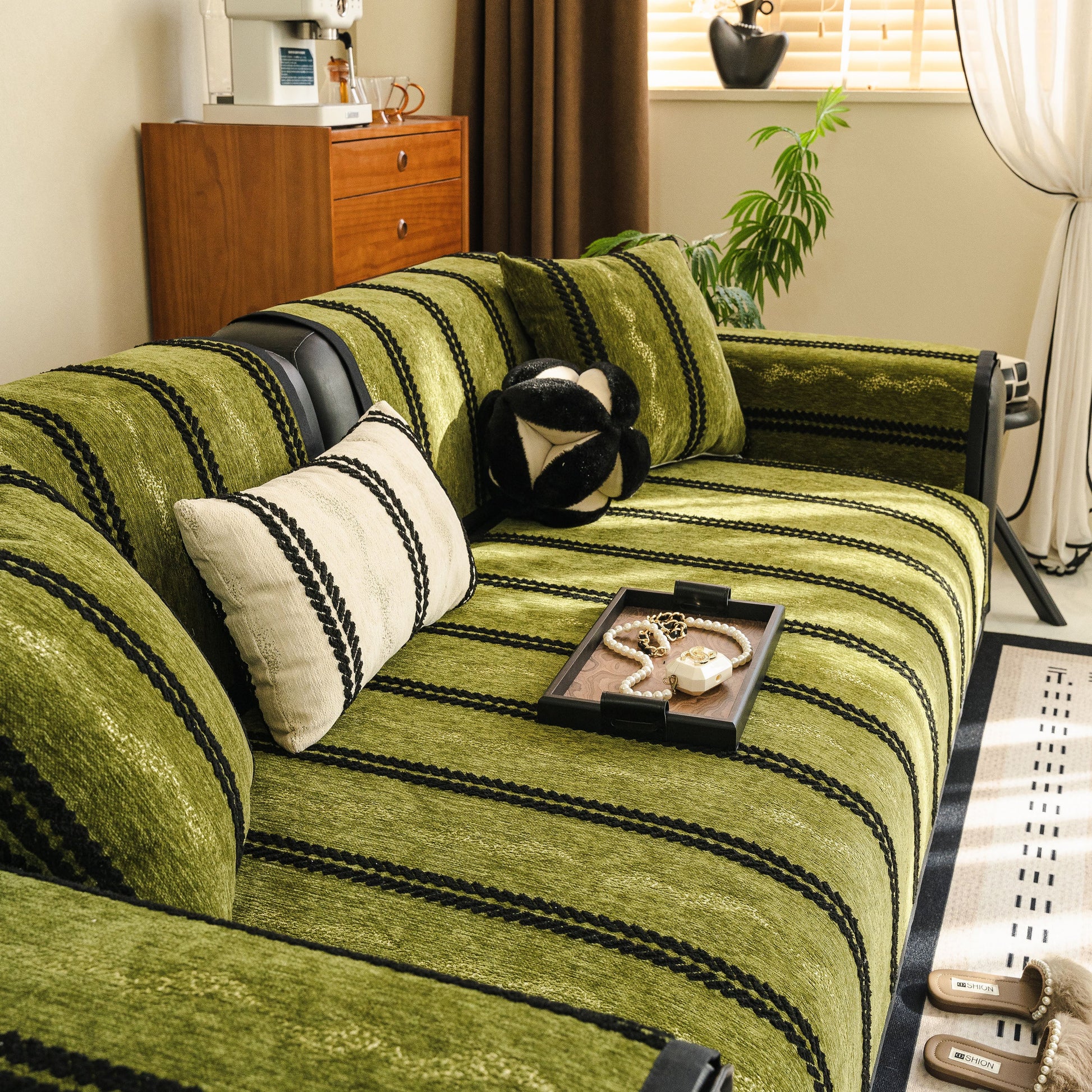 Non-Slip Sofa Cover with Thick Chenille Texture Woven Stripe Couch Protector Throw on a green sofa, offering comfort and protection.