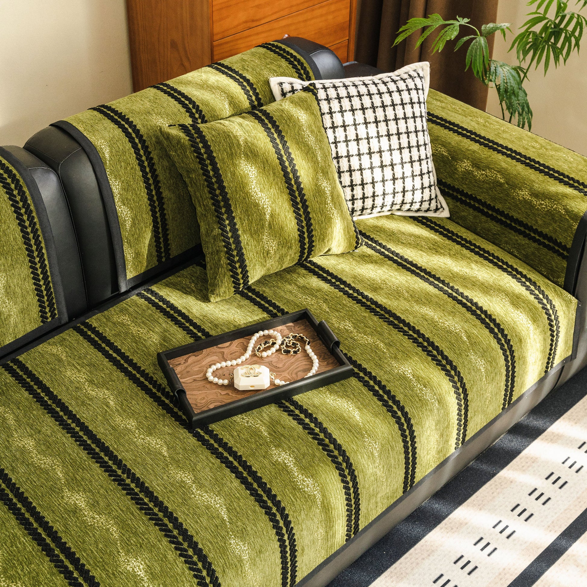 Non-Slip Sofa Cover with Thick Chenille Texture Woven Stripe Couch Protector Throw on a green sofa with decorative pillows and tray
