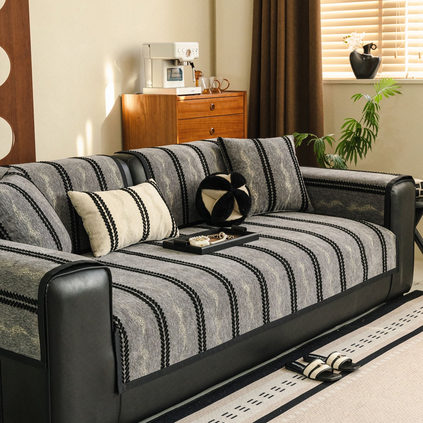 Non-Slip Sofa Cover with Thick Chenille Texture Woven Stripe Couch Protector Throw on a black leather sofa.