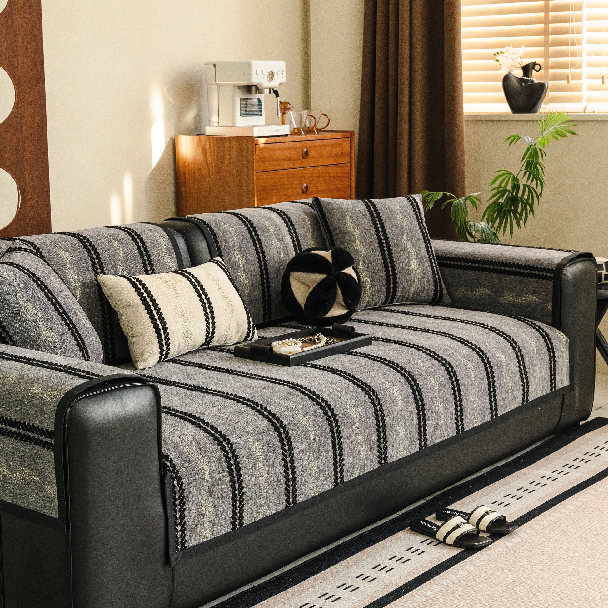 Non-Slip Sofa Cover with Thick Chenille Texture Woven Stripe Couch Protector Throw on a black leather sofa.