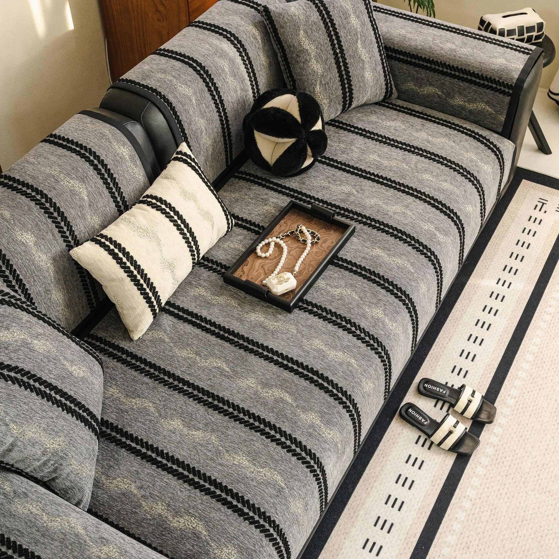 Non-Slip Sofa Cover with Thick Chenille Texture Woven Stripe Couch Protector Throw on gray sofa with decorative pattern.