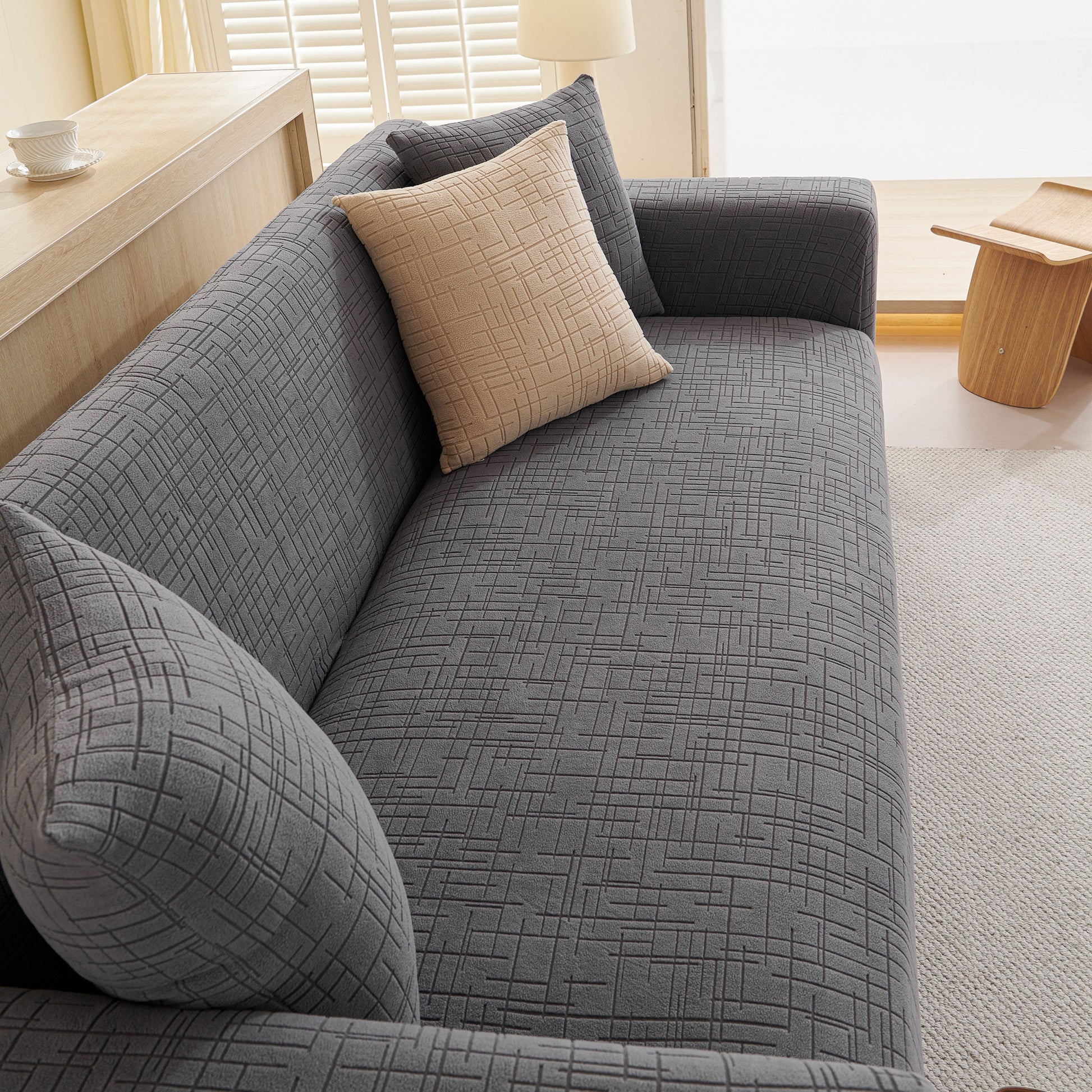 Gray couch with Embossed Lines Couch Covers Stretchable Non-Slip & Washable Sofa Slipcovers, featuring a beige pillow and modern design.