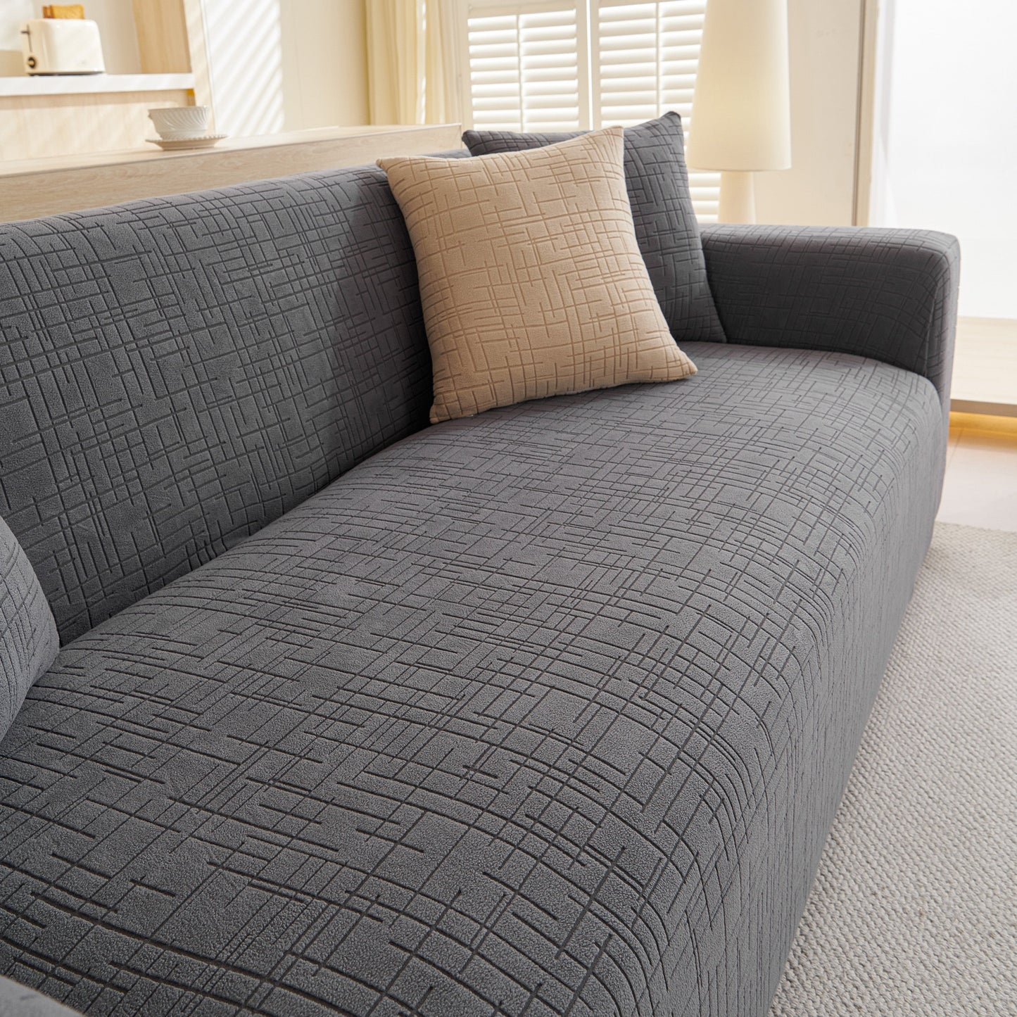 Embossed Lines Couch Covers Stretchable Non-Slip & Washable Sofa Slipcovers on a gray sofa in a bright living room