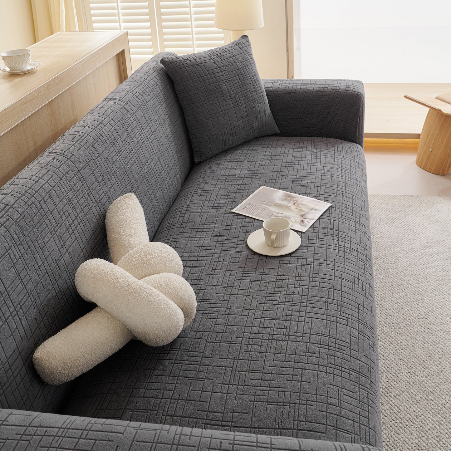 Embossed Lines Couch Covers Stretchable Non-Slip & Washable Sofa Slipcovers on a grey sofa with a pillow and magazine