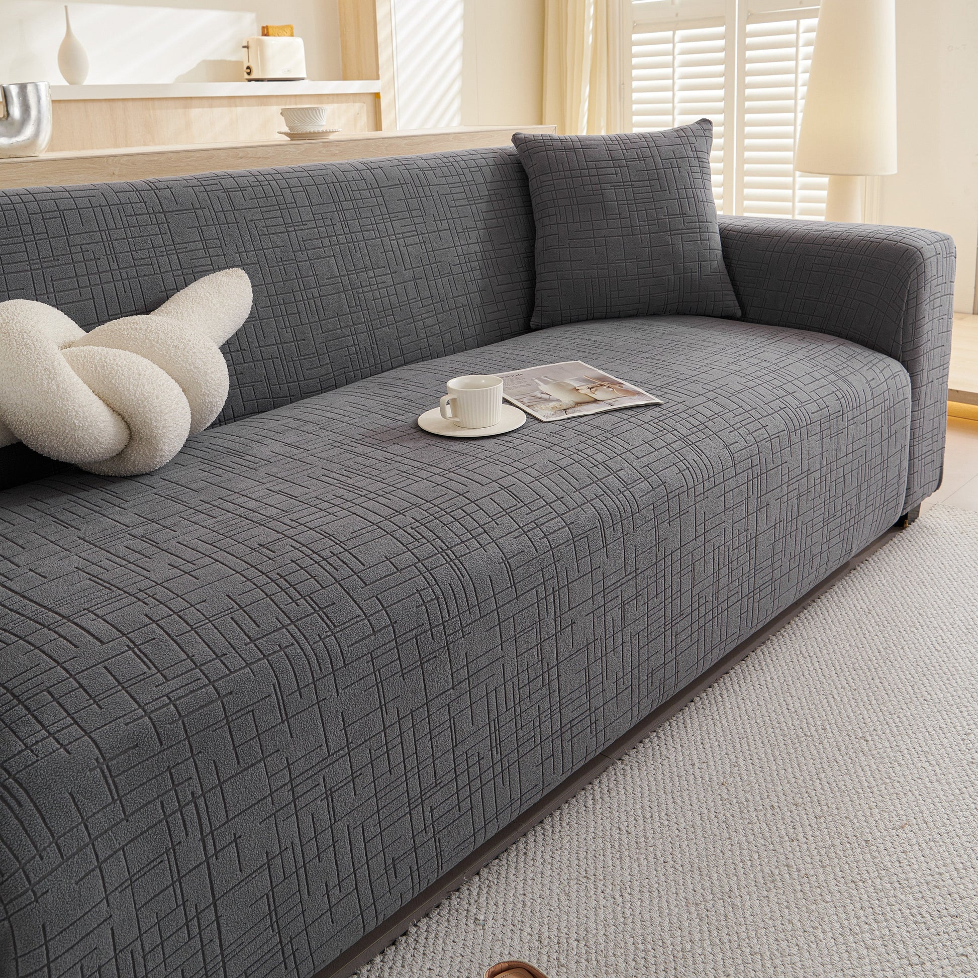 Embossed Lines Couch Covers Stretchable Non-Slip & Washable Sofa Slipcovers on a modern grey couch in a bright living room.