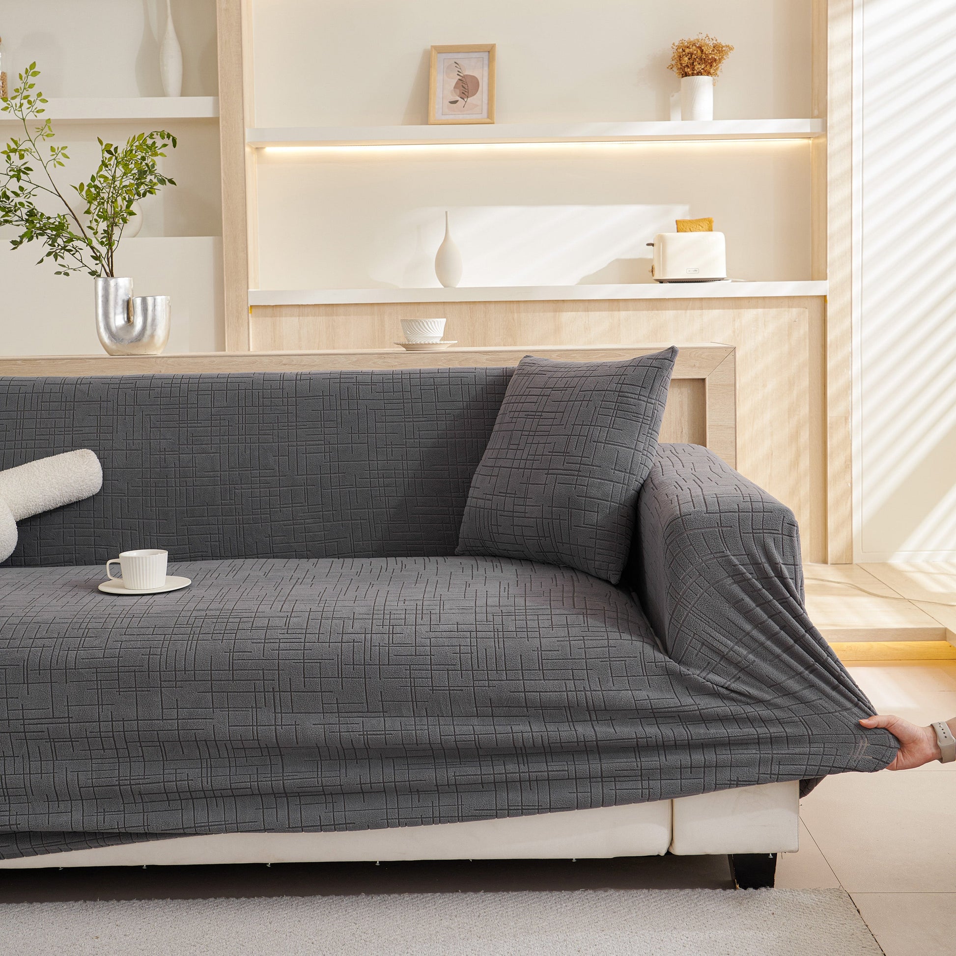 Embossed Lines Couch Covers Stretchable Non-Slip & Washable Sofa Slipcovers on a gray couch in a modern living room.