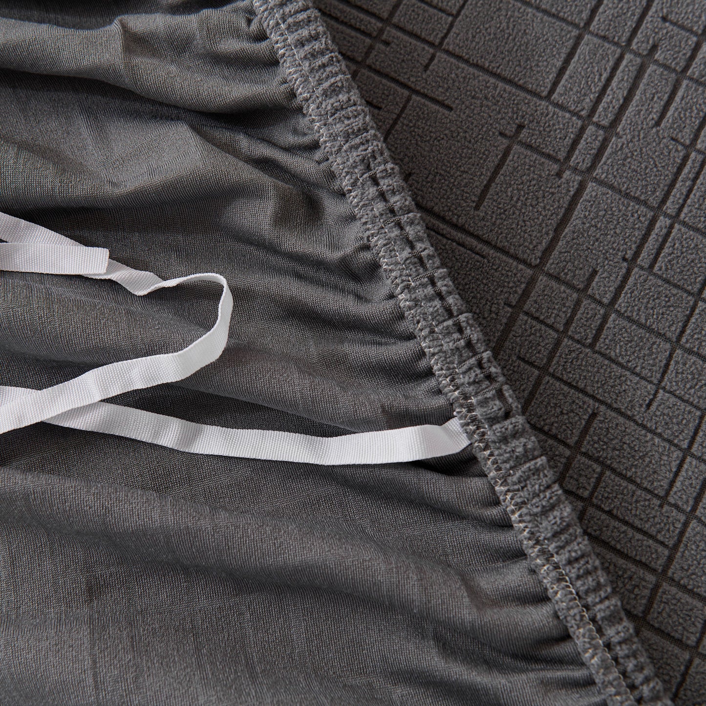 Close-up of gray Embossed Lines Couch Covers Stretchable Non-Slip & Washable Sofa Slipcovers showing texture and elastic edge.