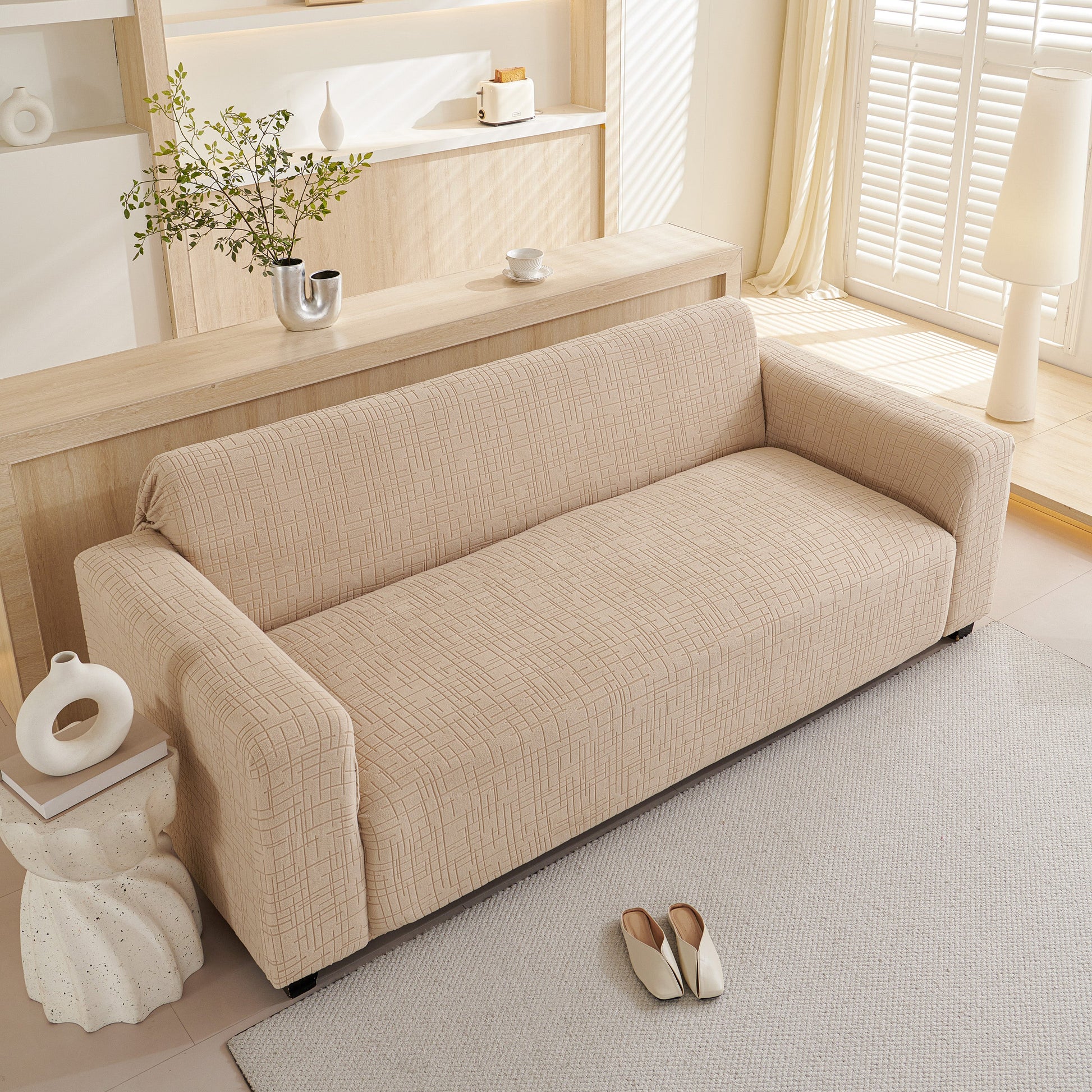 Embossed Lines Couch Covers Stretchable Non-Slip & Washable Sofa Slipcovers on a beige couch in a bright living room.