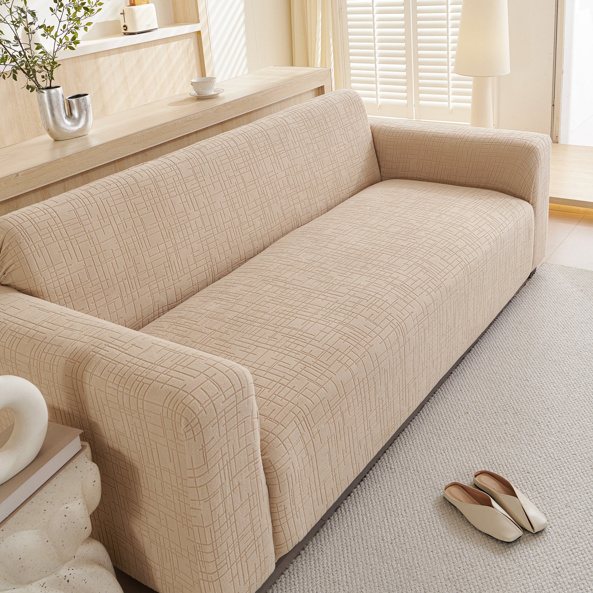 Embossed Lines Couch Covers Stretchable Non-Slip & Washable Sofa Slipcovers on a beige sofa for dust and spill protection.