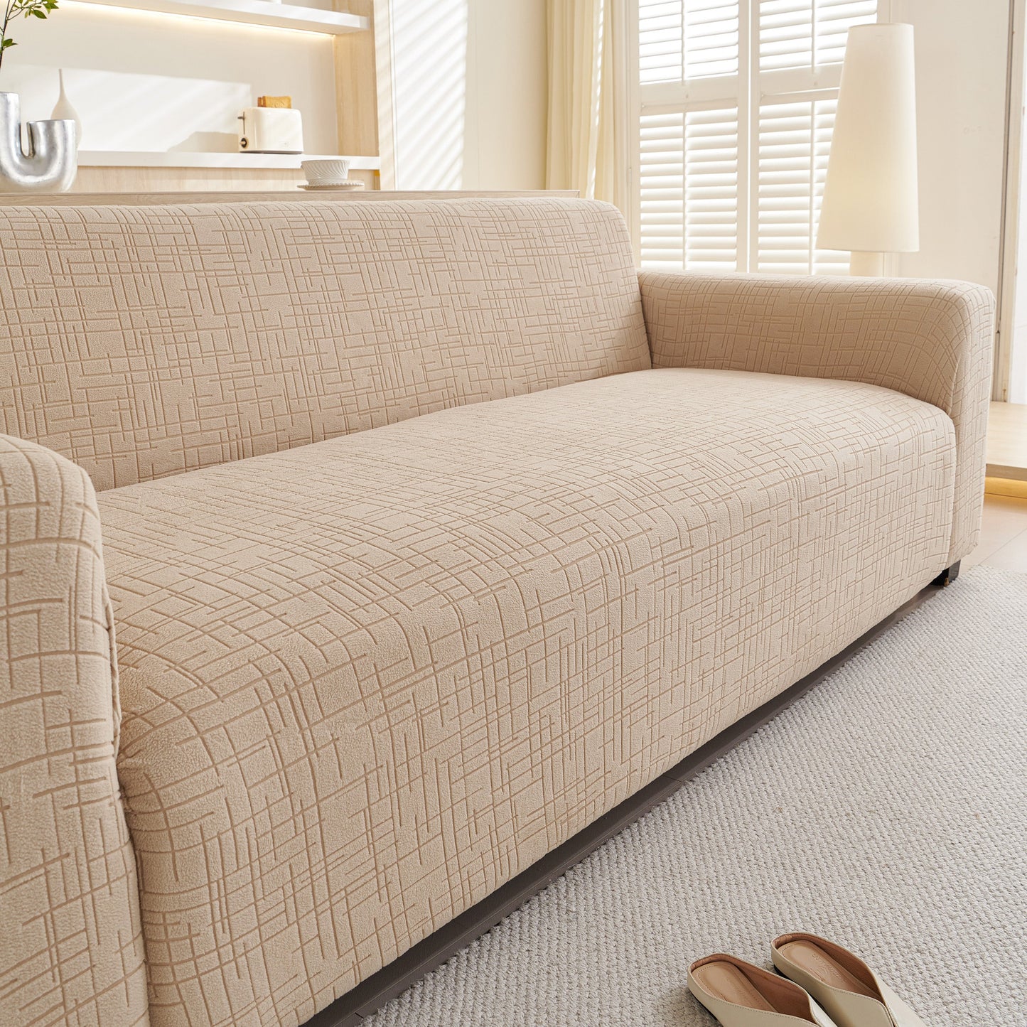Embossed Lines Couch Covers Stretchable Non-Slip & Washable Sofa Slipcovers on a beige couch in a bright living room.
