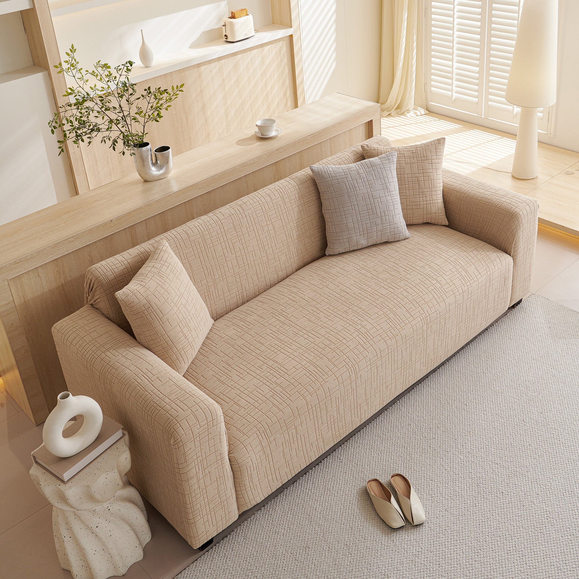 Embossed Lines Couch Covers Stretchable Non-Slip & Washable Sofa Slipcovers on a beige couch in a bright living room