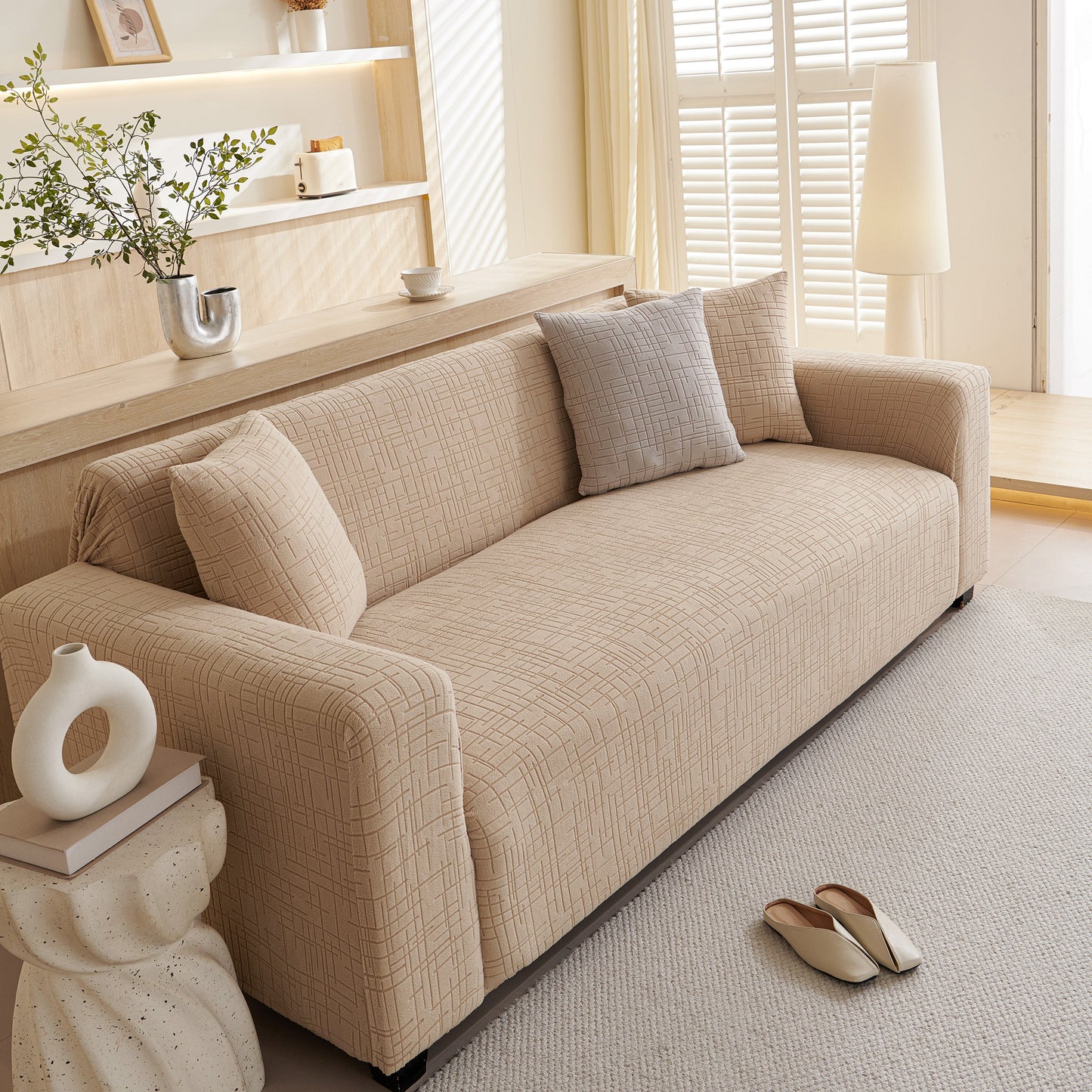 Cozy living room with embossed lines couch cover, stretchable non-slip & washable sofa slipcovers on a beige couch.